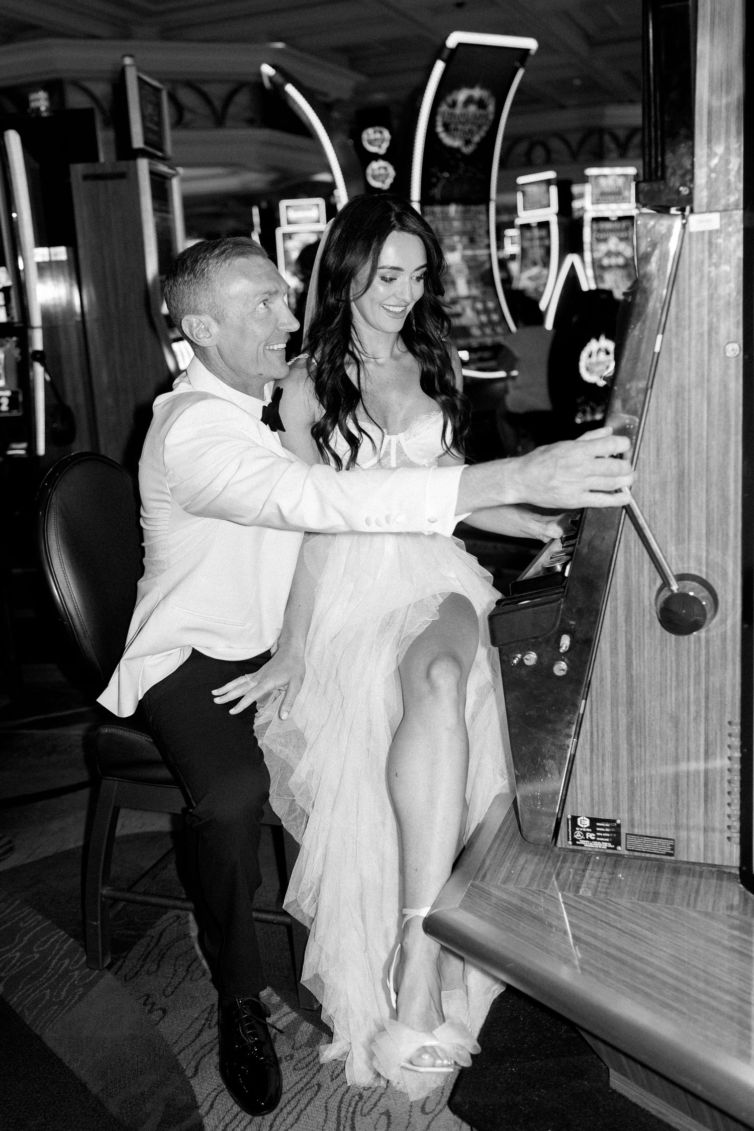 Wedding couple having fun taking photos in a casino gaming area.
