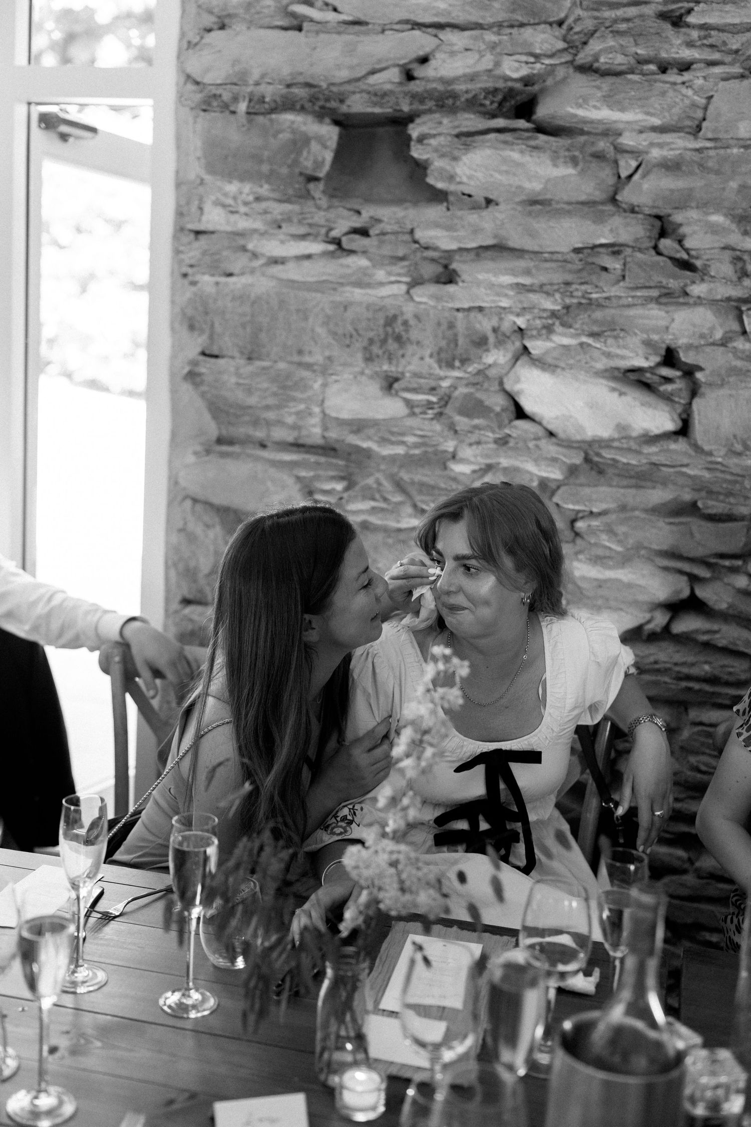 Intimate moments captured during a wedding reception in a rustic stone venue with candlelit tables.