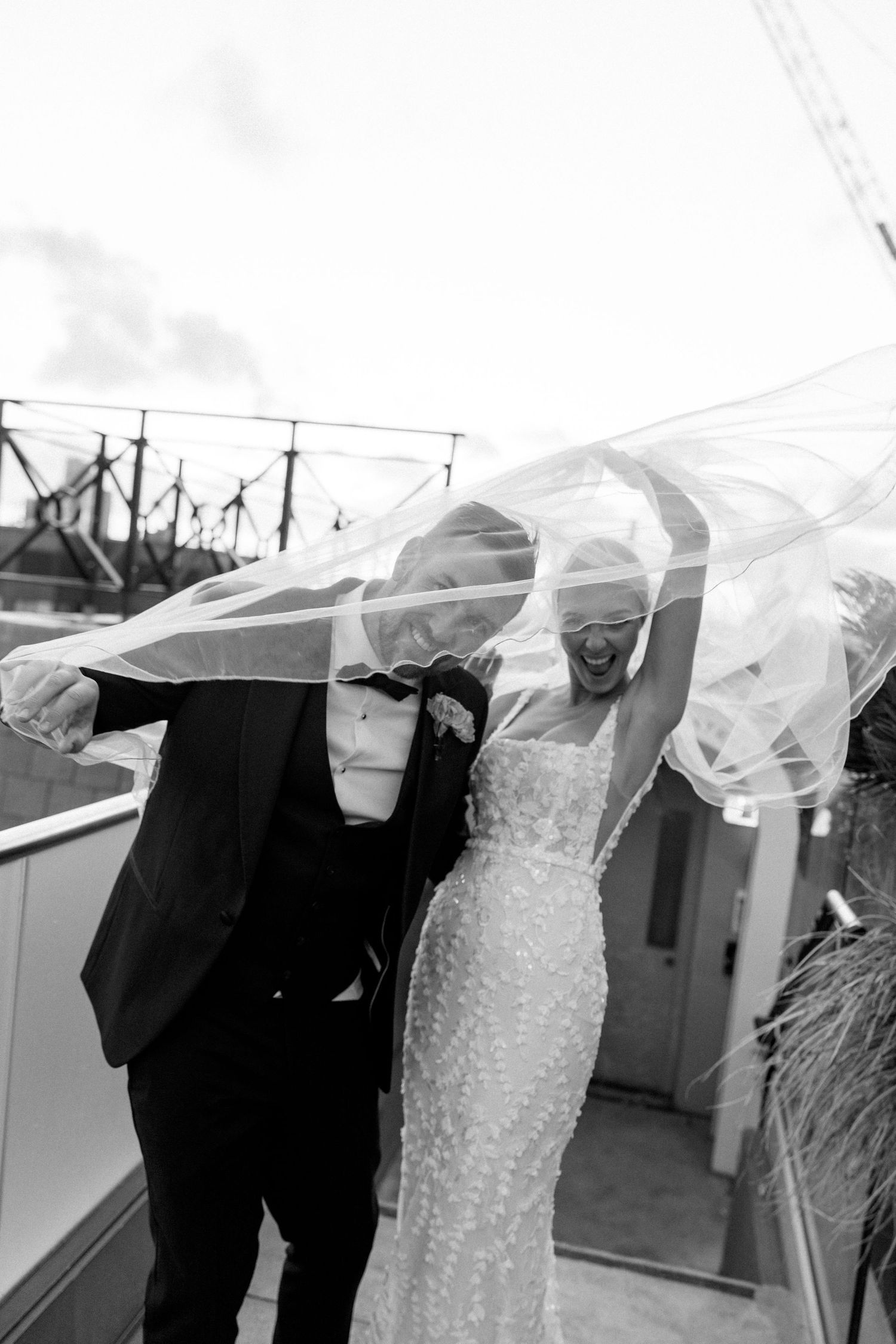 Wedding veil flowing in the wind during rooftop photo session.