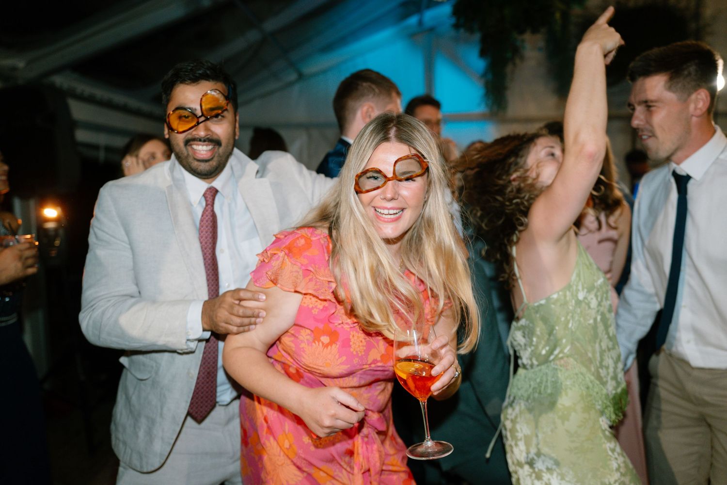 Guests in colorful attire mingling and enjoying drinks at an evening party.
