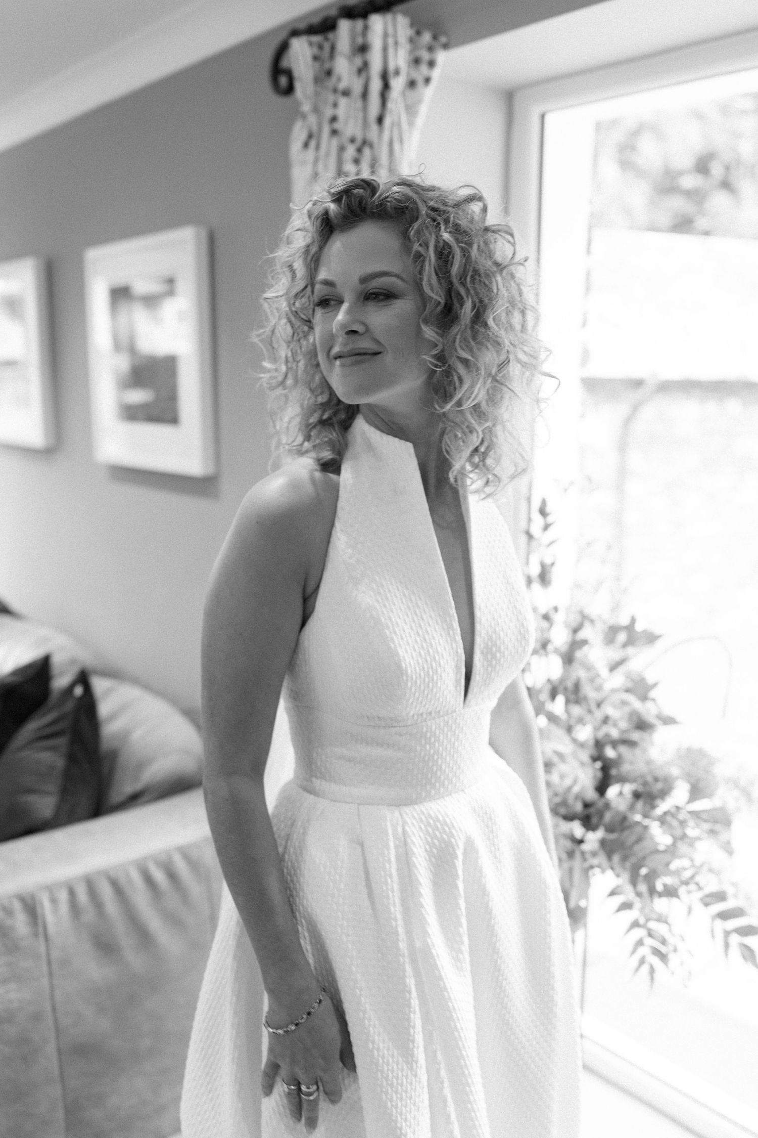 Elegant bridal portrait in white dress against bright window light.