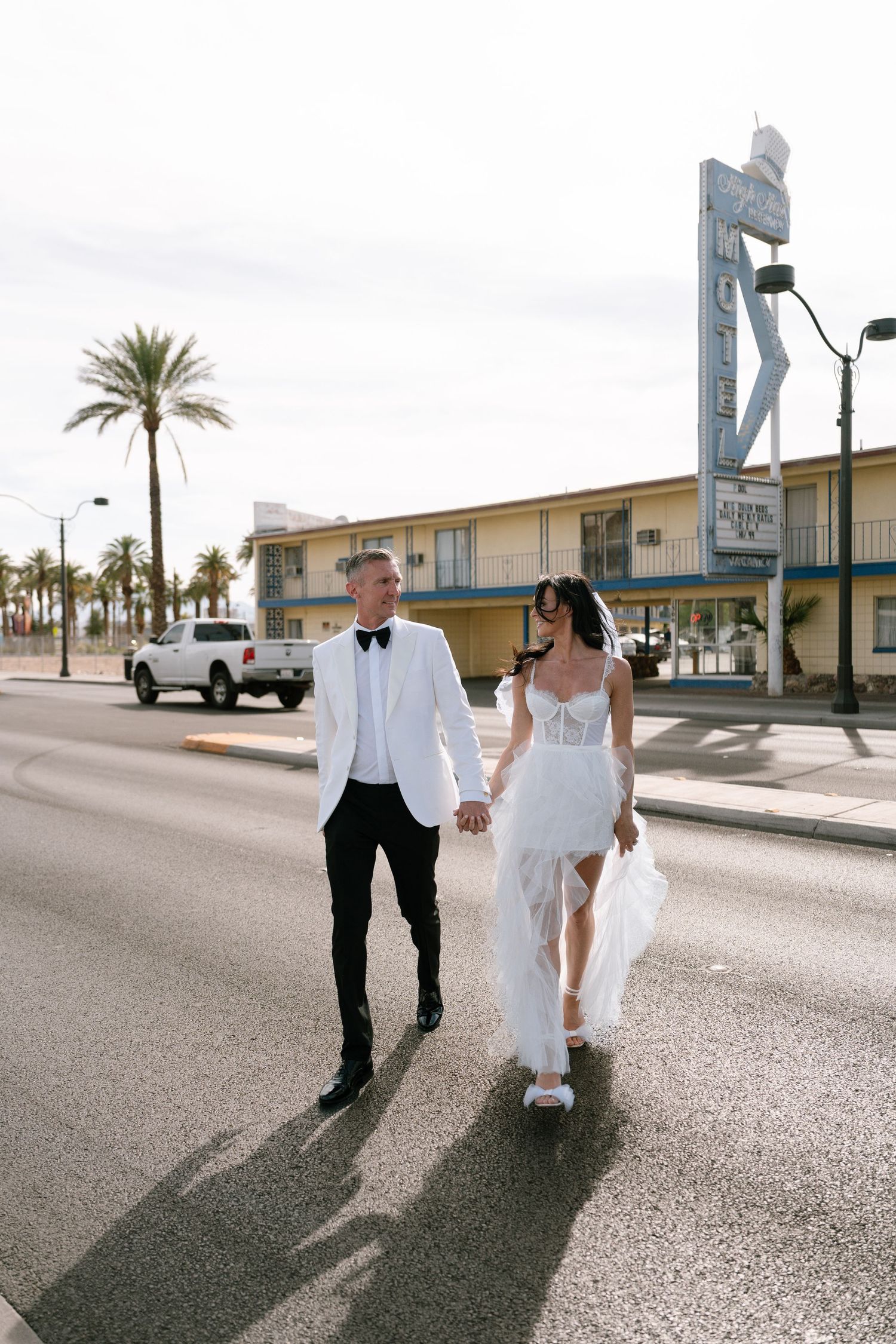 Wedding couple takes casual photos while walking down a Las Vegas street.