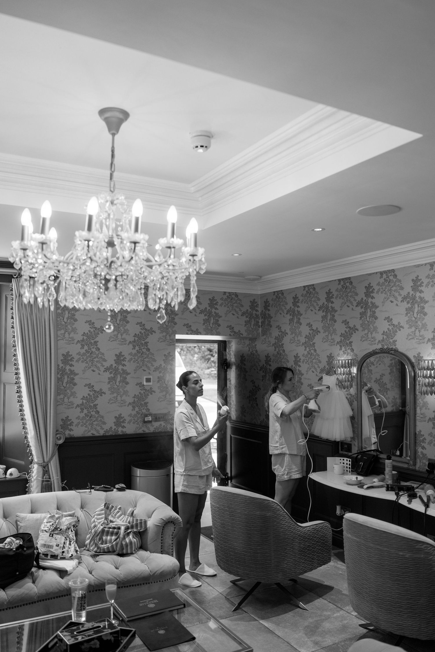 Elegant room interior with crystal chandeliers and floral wallpaper.
