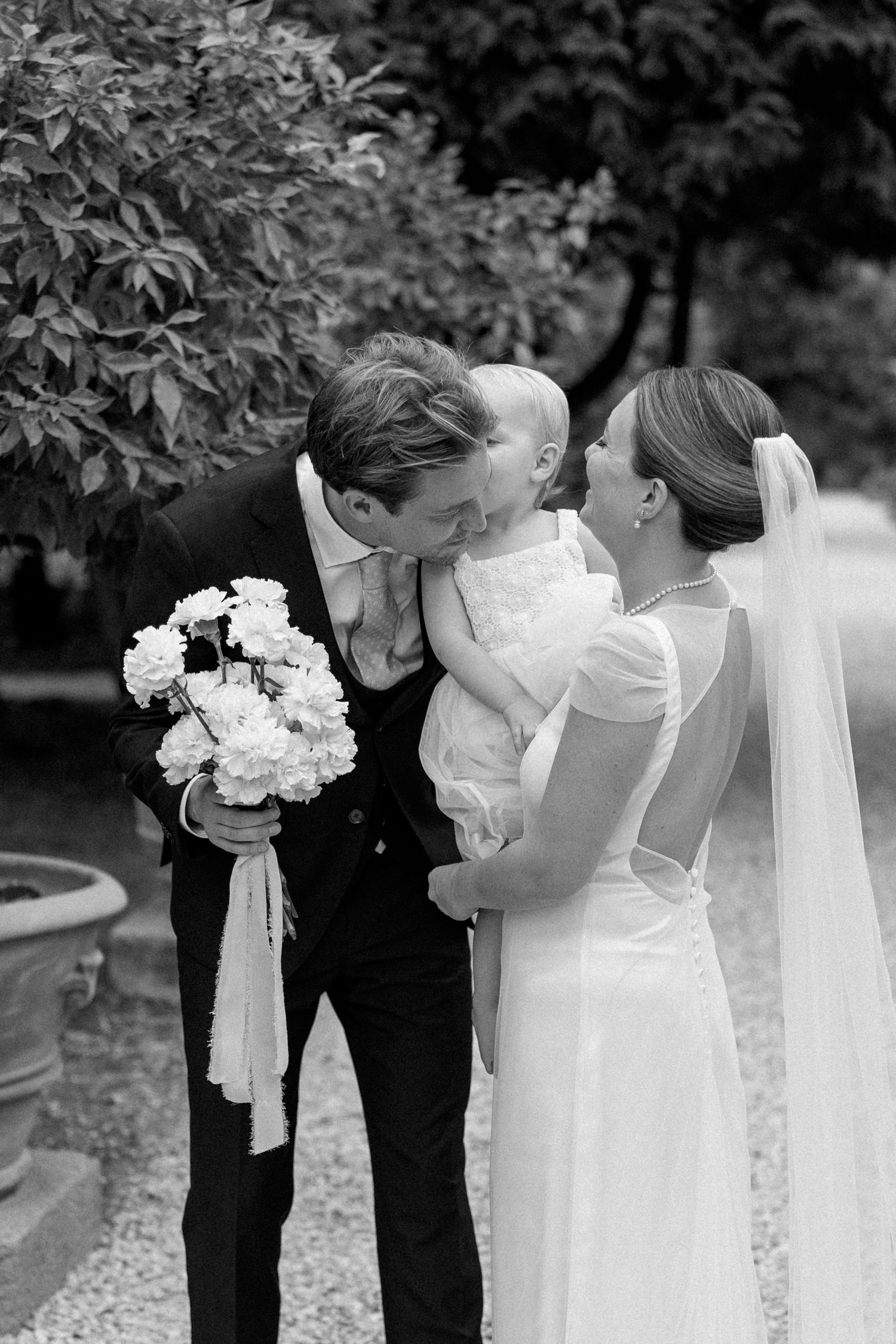 A sequence of intimate wedding moments captured in black and white with white floral bouquets.