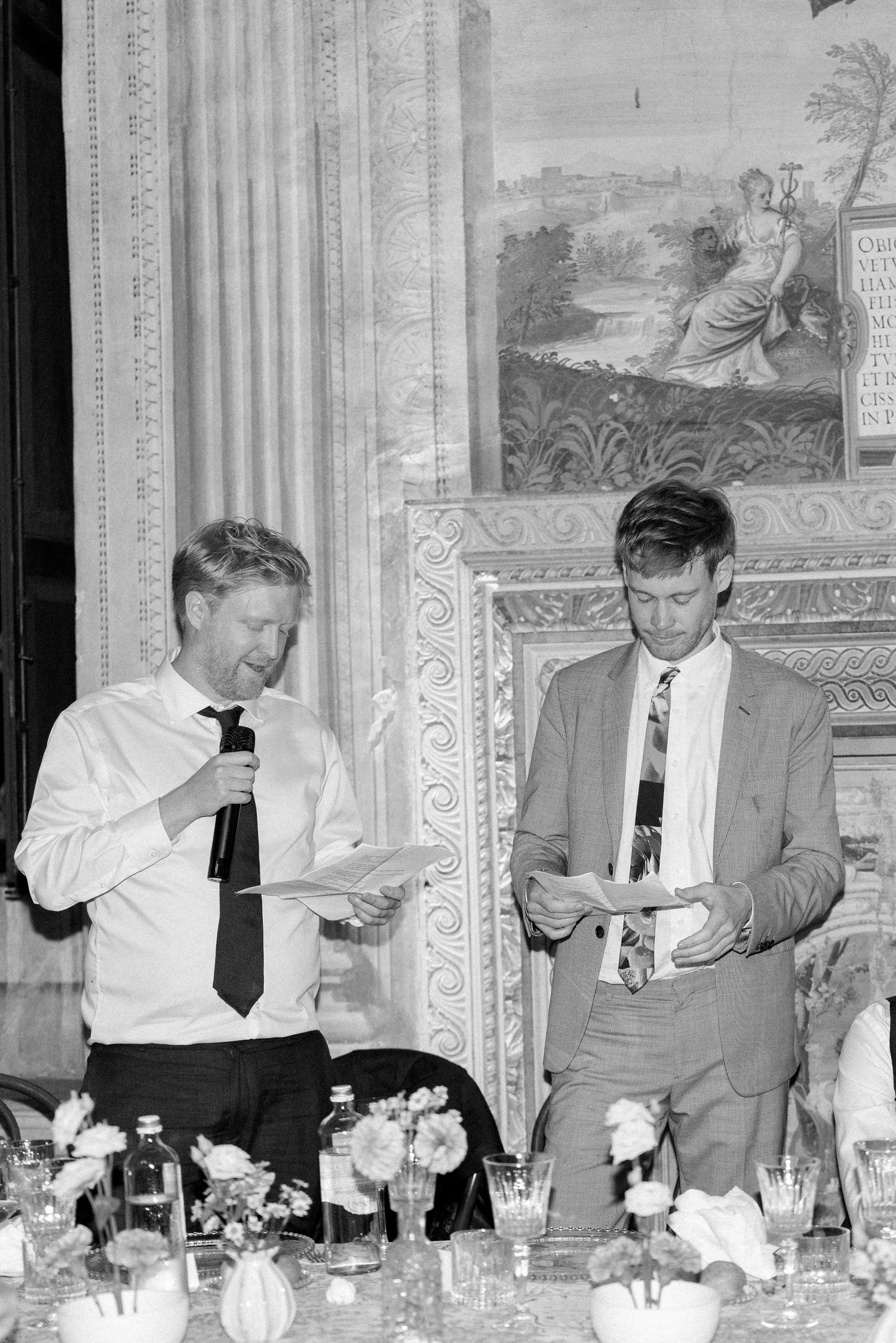 Group of men in ties seated at formal dinner table in vintage black and white photograph.