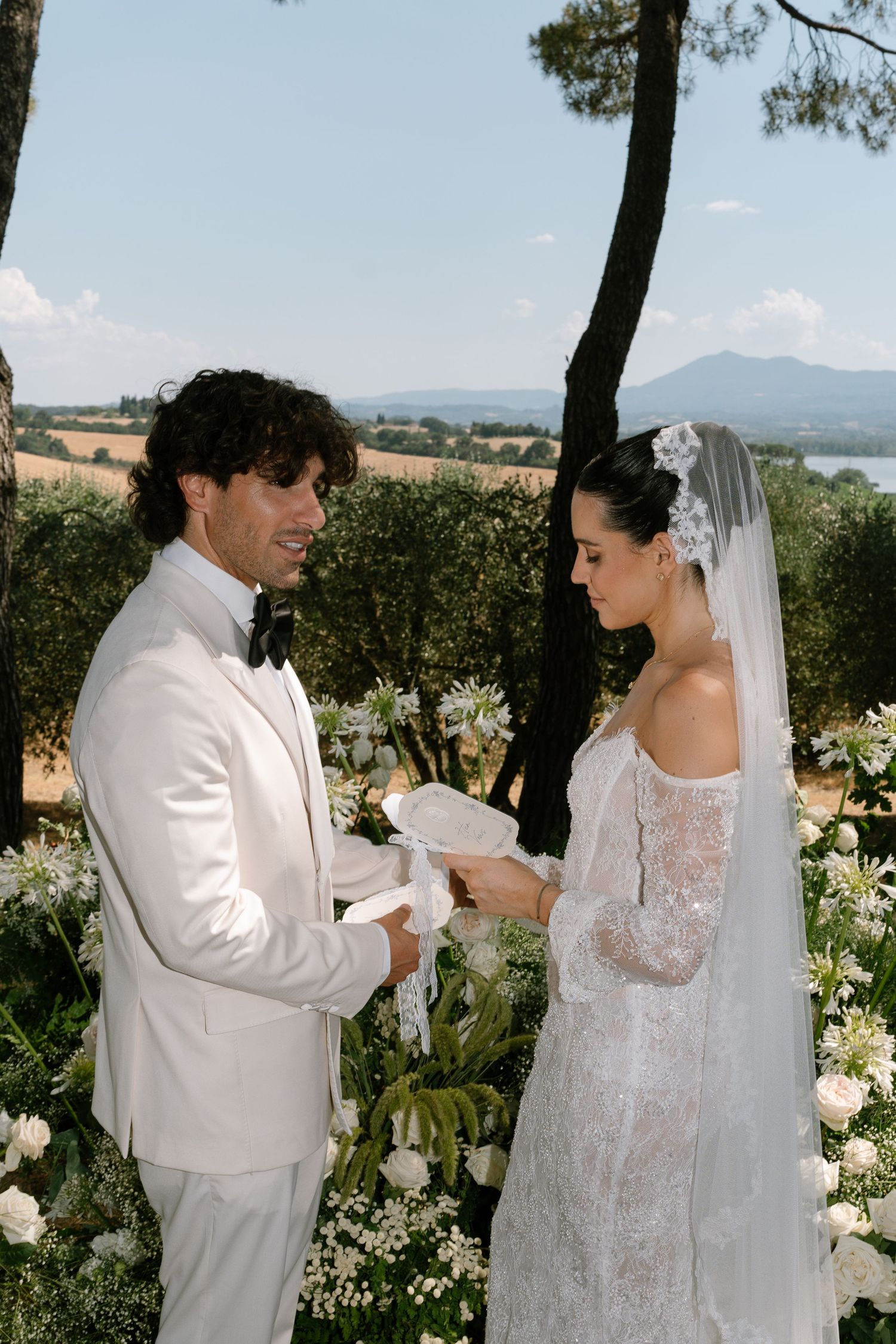 An intimate wedding ceremony moment in a sun-drenched garden setting.