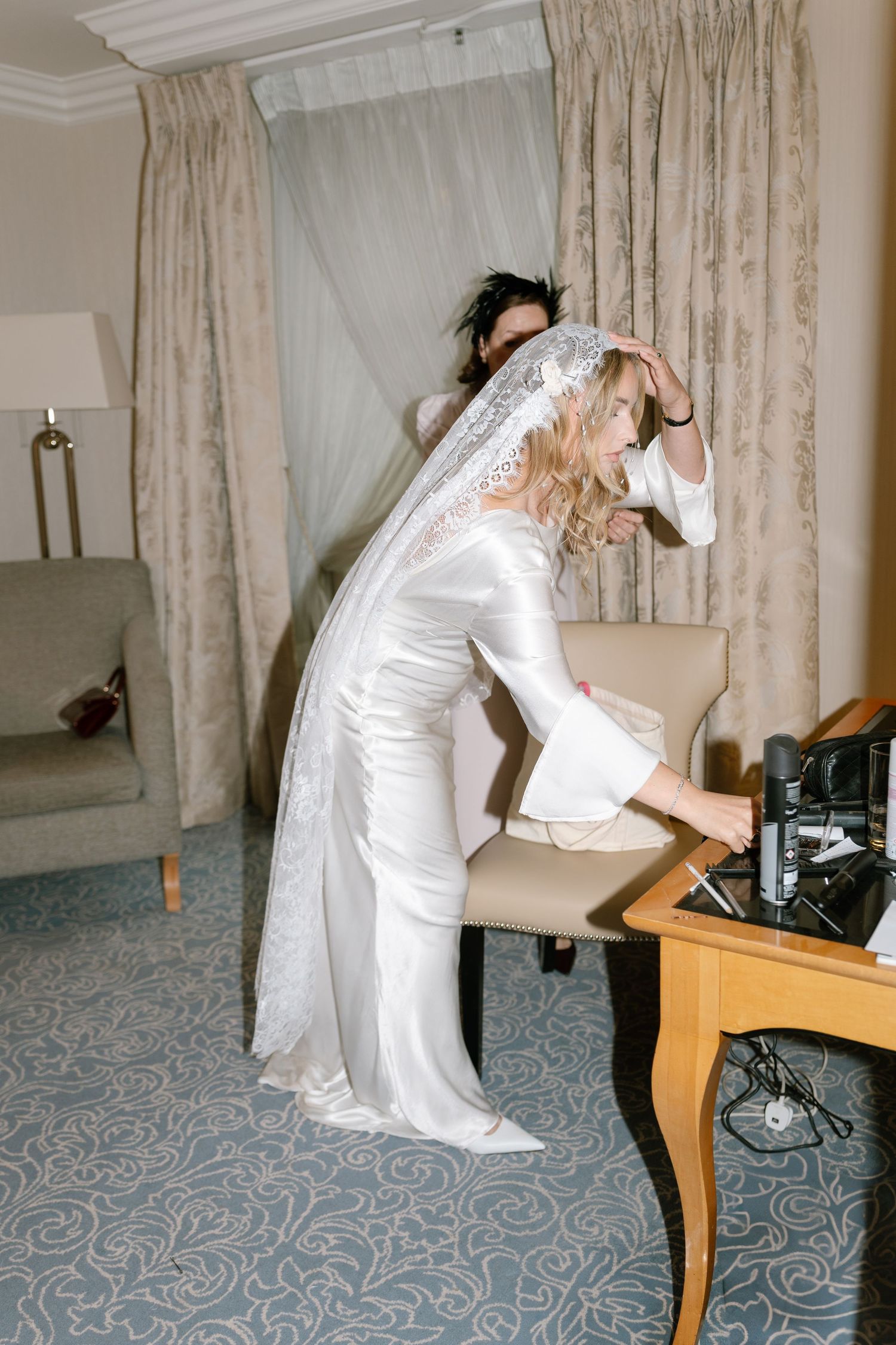 Five sequential photos showing someone in a white dress bending over a desk in a room with patterned carpet.