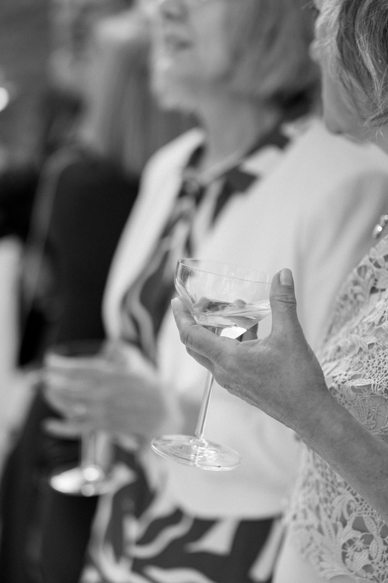Black and white close-up of hands during wedding celebration.