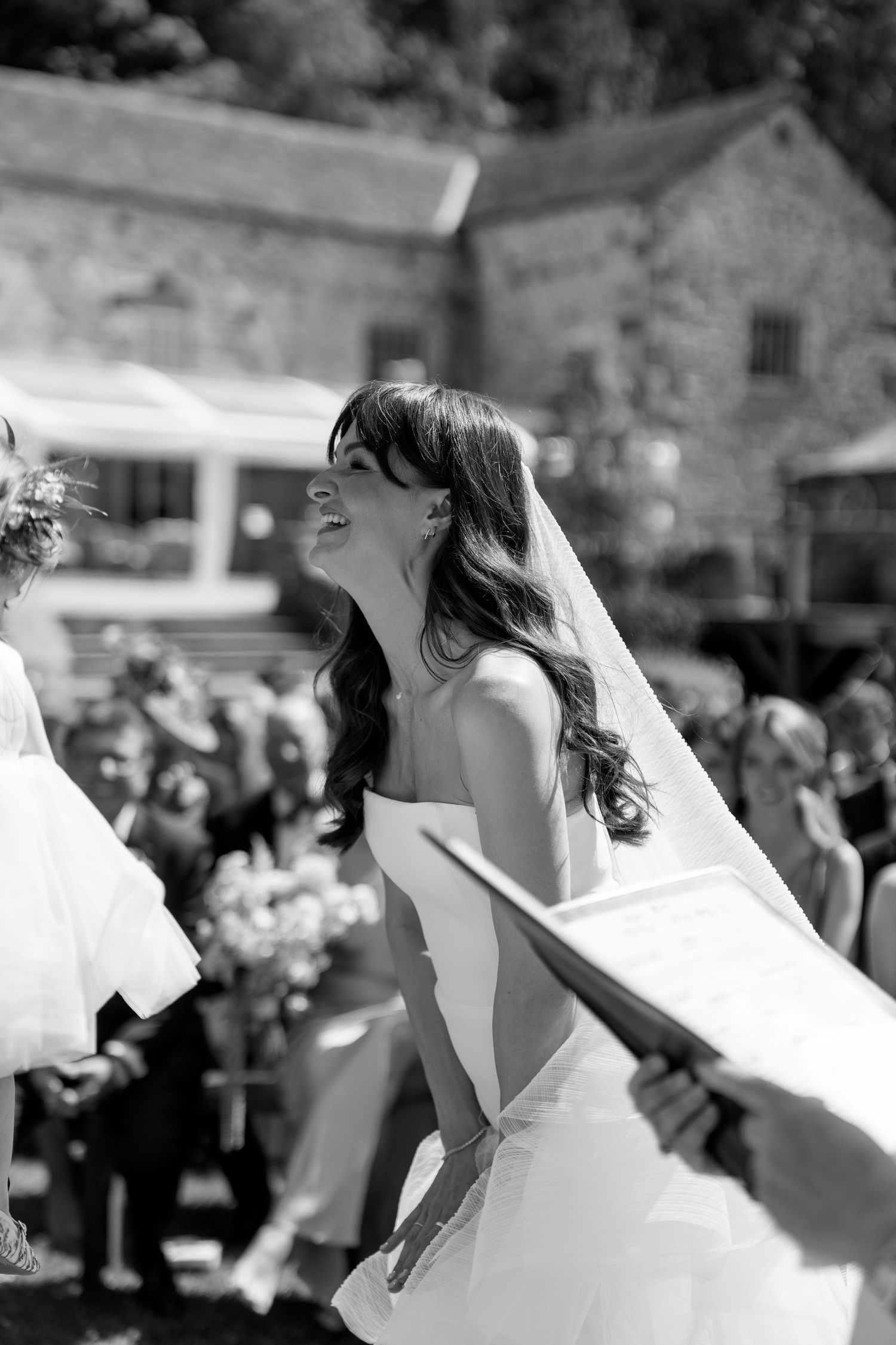 Black and white photo captures flowing wedding dress movement during outdoor dance.