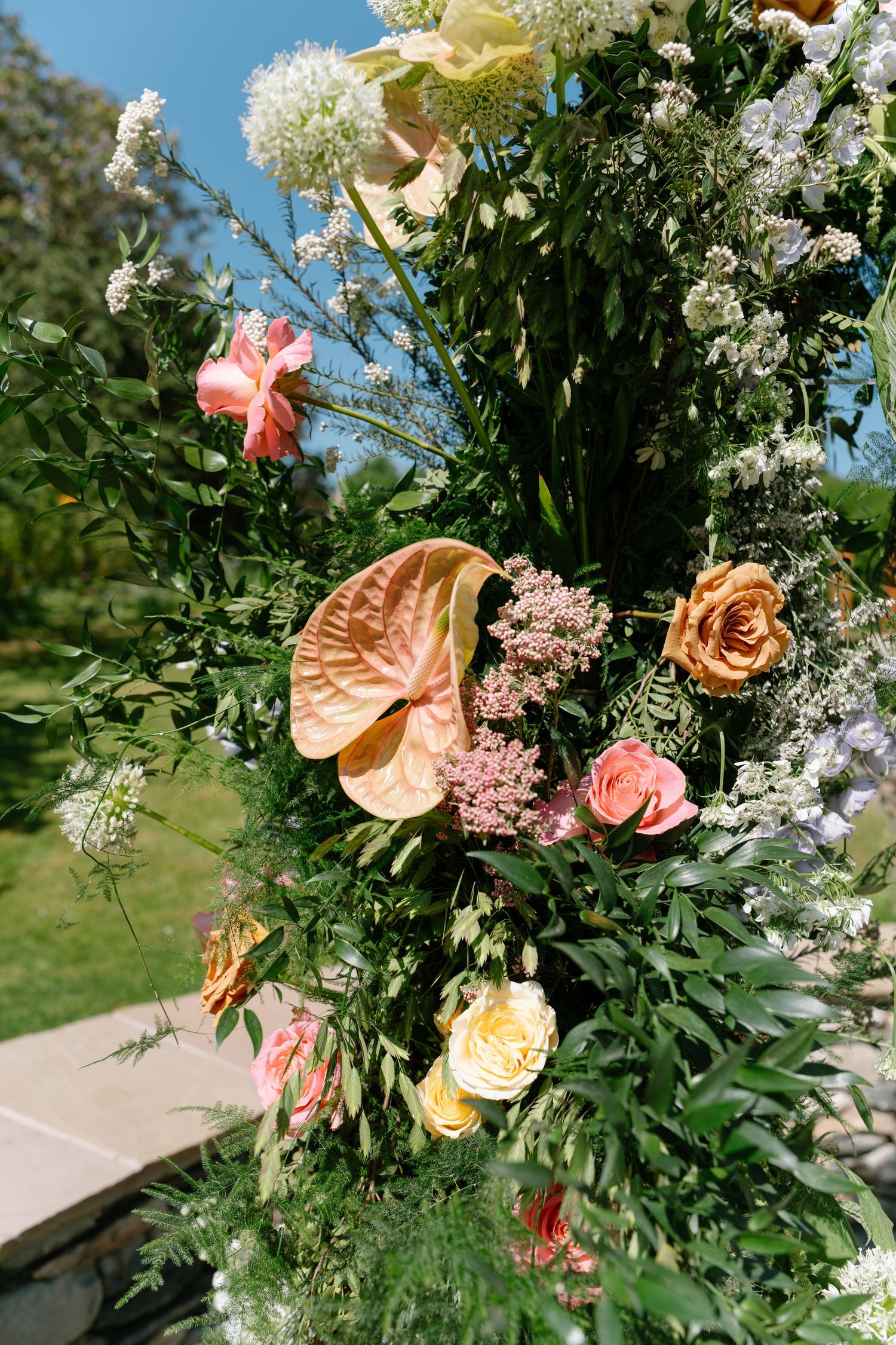 Close-up view of a lush garden-style flower arrangement featuring roses and delicate white blooms.