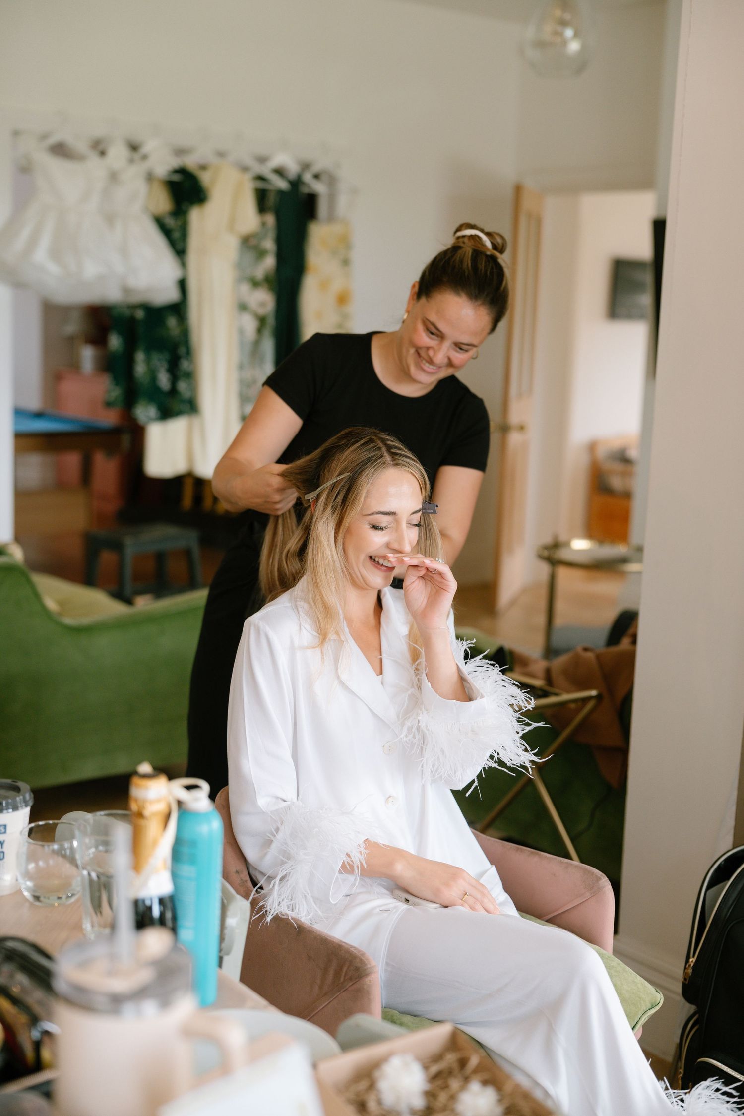 Interior scene of hair styling session with white robe and laughter.