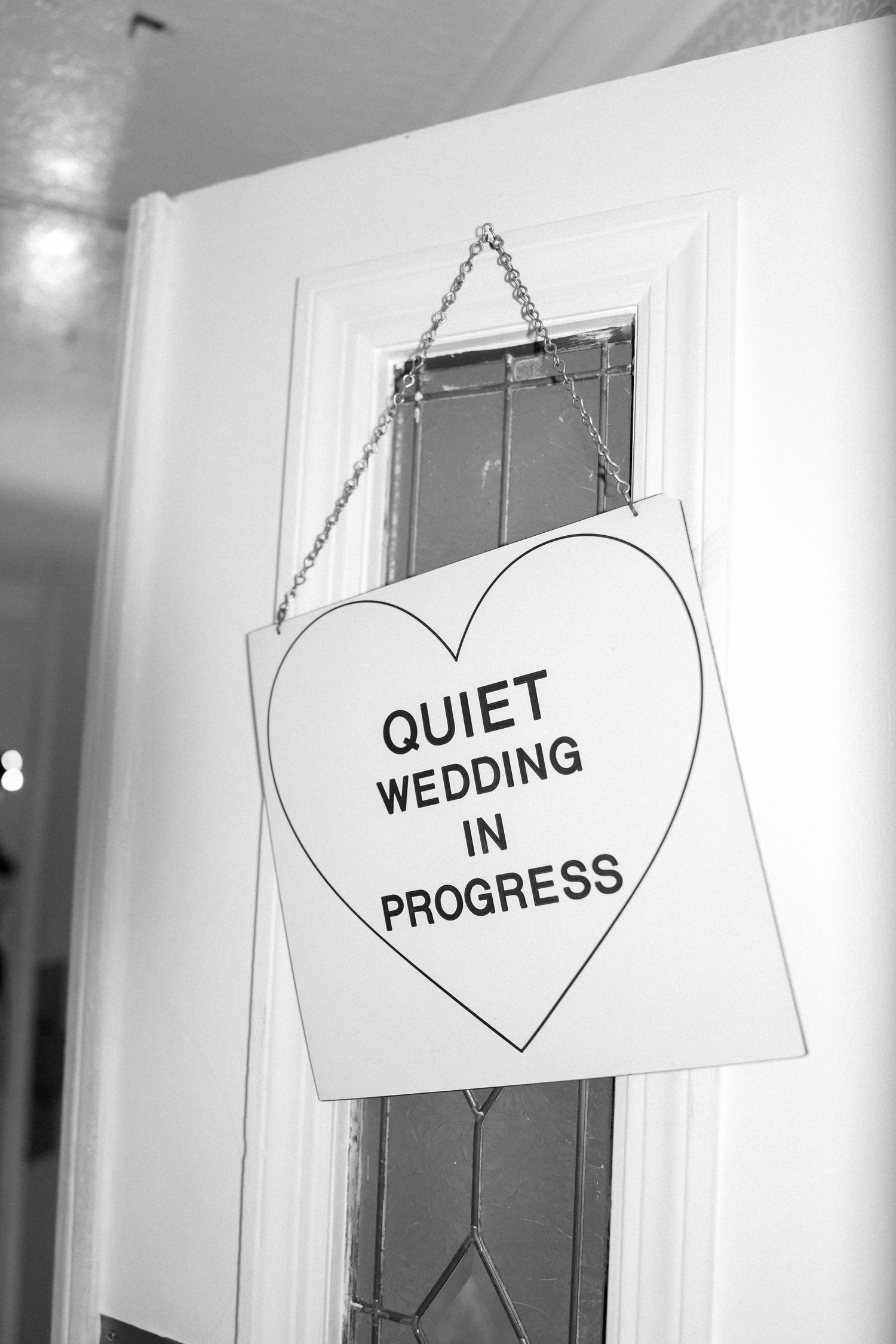 Black and white signs with heart shapes reading 'Quiet Wedding in Progress'.