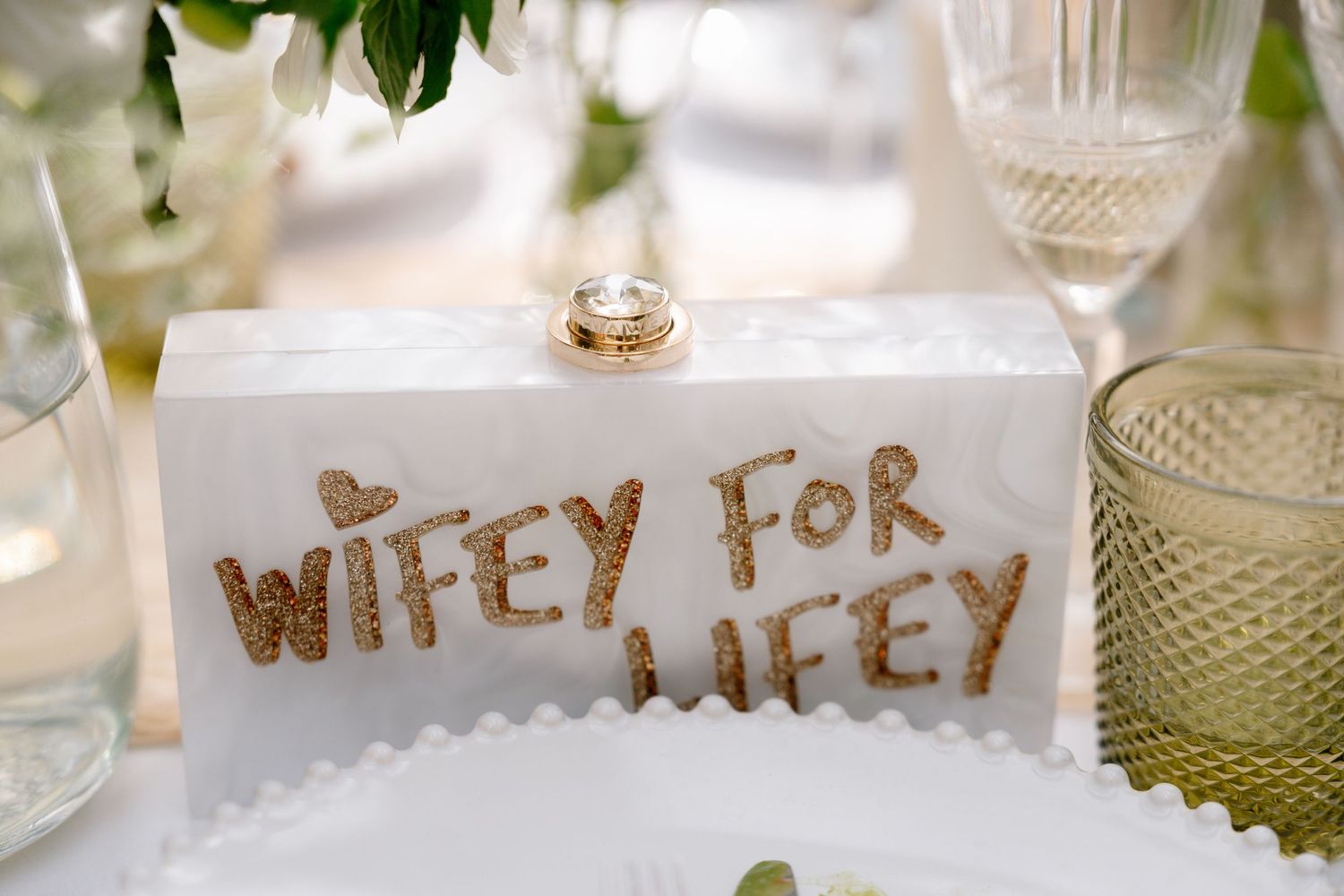 Elegant table setting with crystal glassware and gold lettering decorations.
