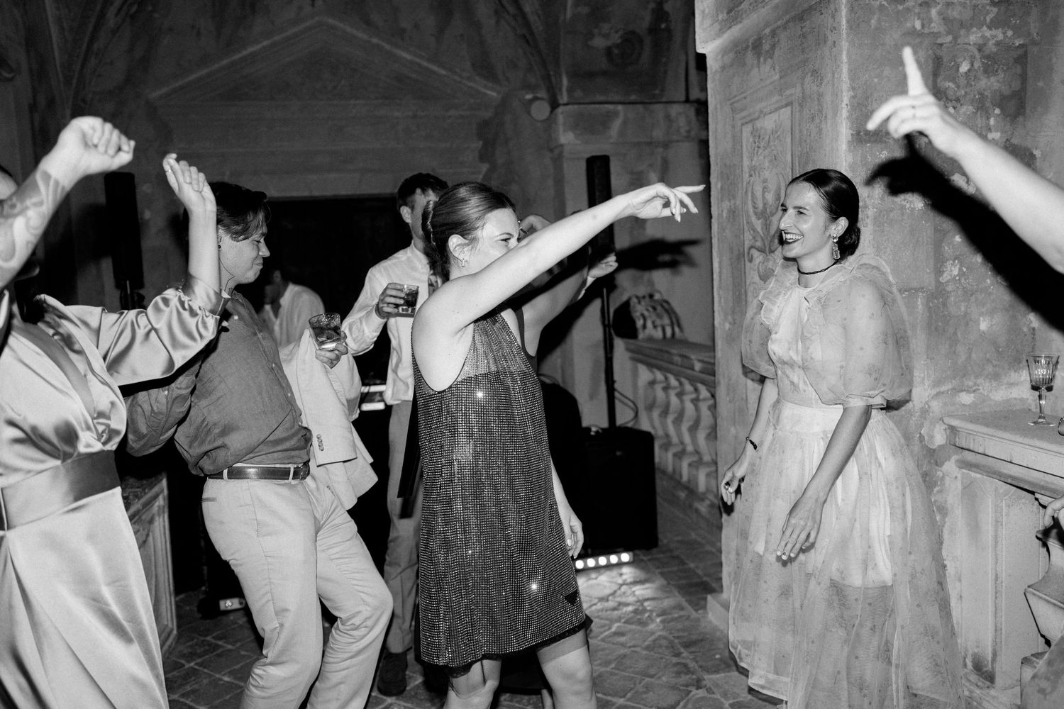 Black and white photo showing dancers enjoying themselves in an ornate ballroom setting.