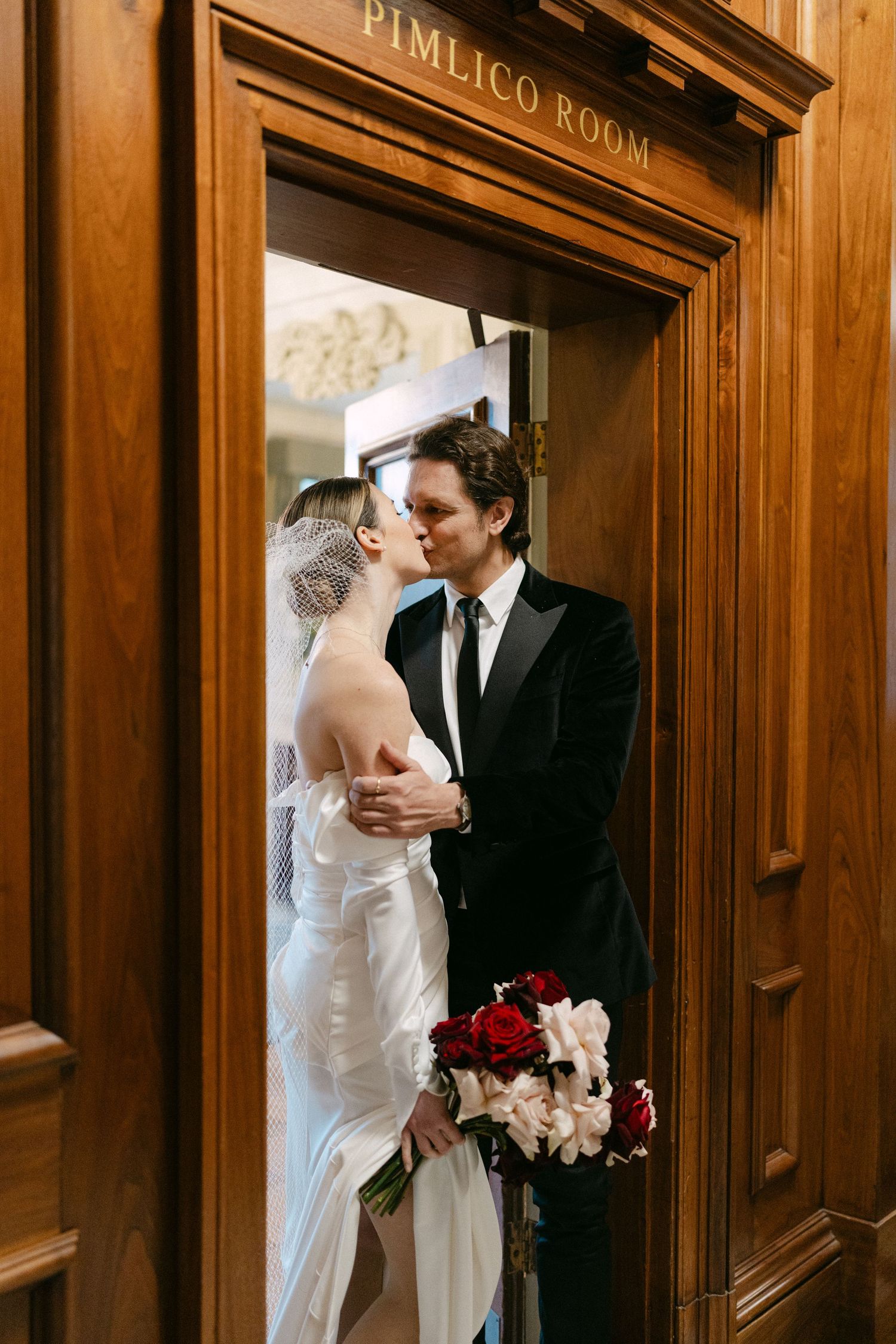 Wedding photos taken in front of wood-paneled walls with a sign reading 'Pimlico Room'.