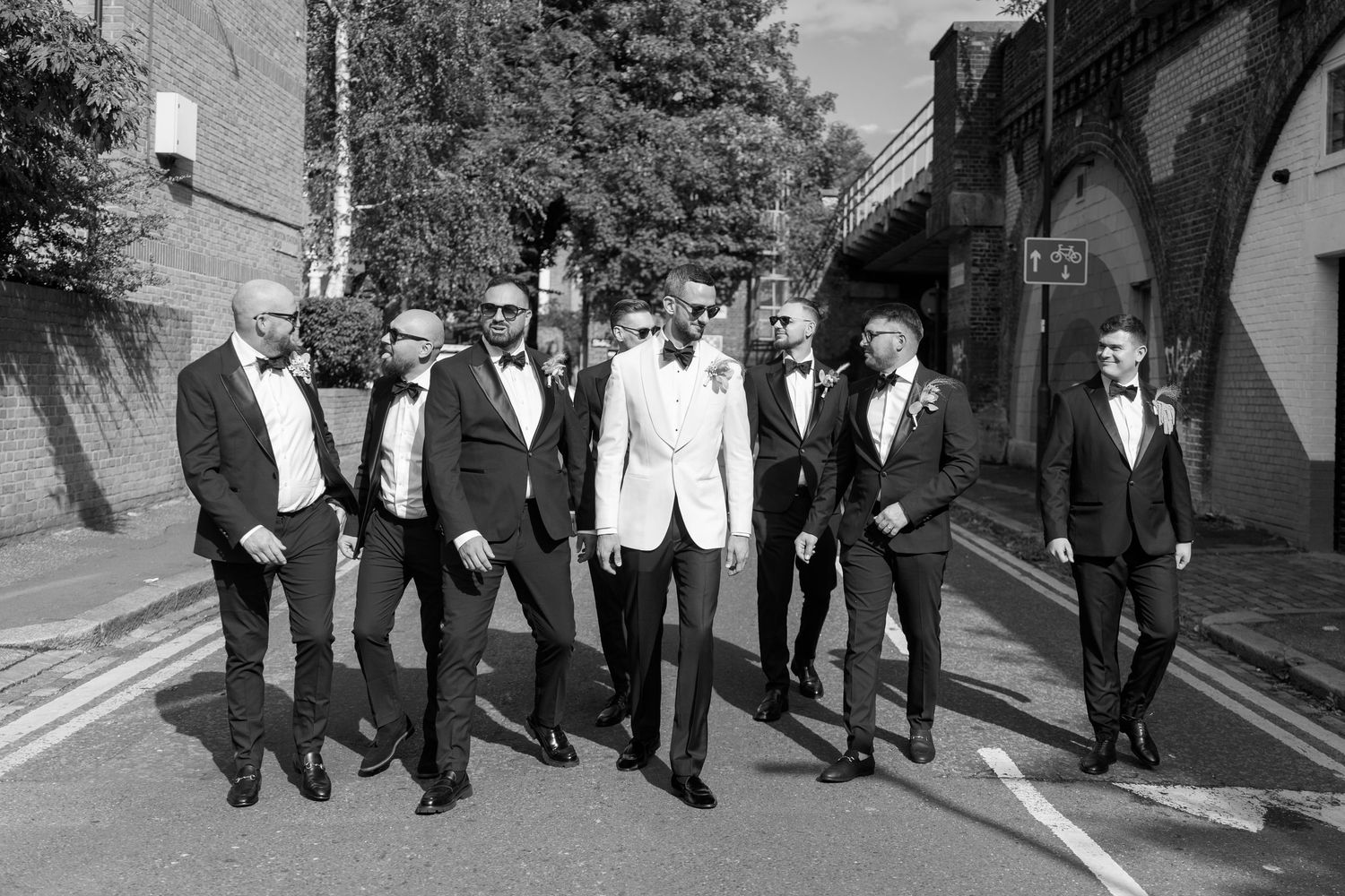 Black and white photo of wedding party walking together outdoors.