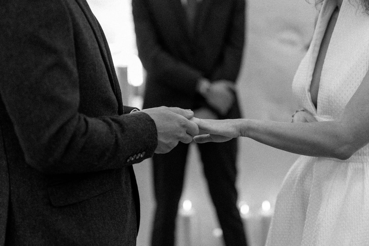 Close-up of hands exchanging rings during an intimate wedding ceremony.