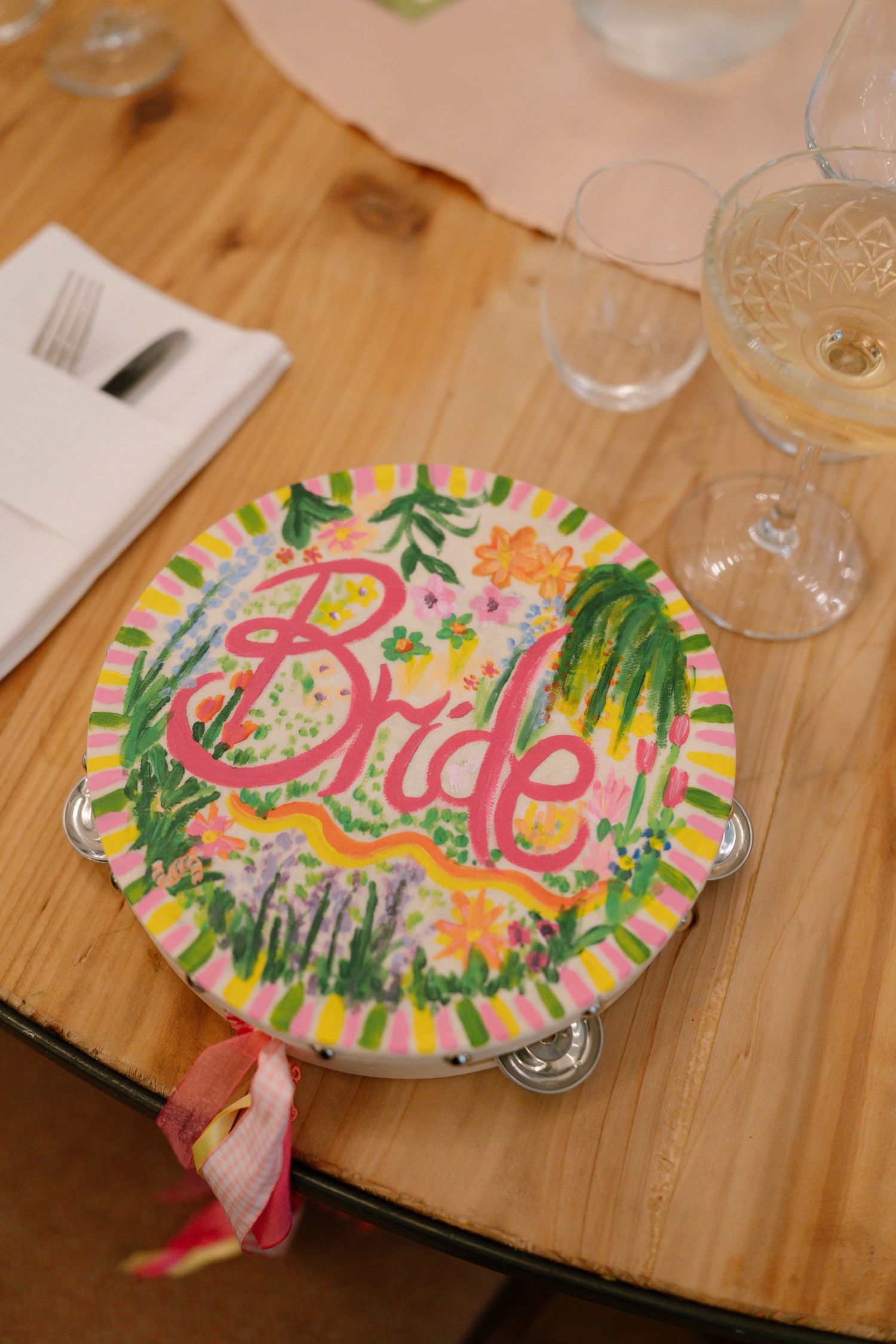A decorative plate with 'Bride' written in pink surrounded by floral designs.