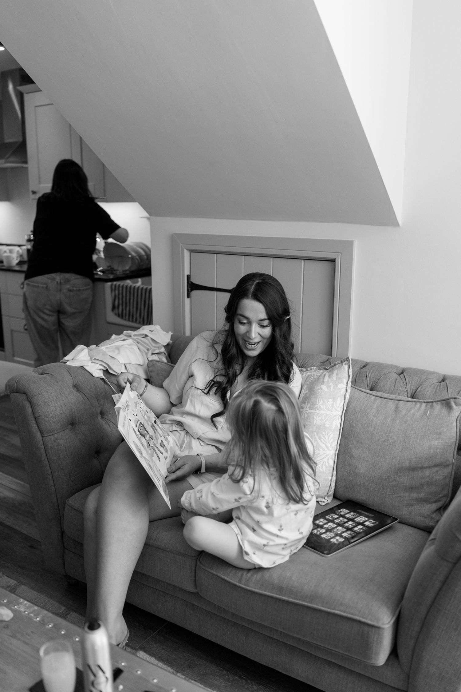 Black and white photos of someone relaxing on a grey couch.