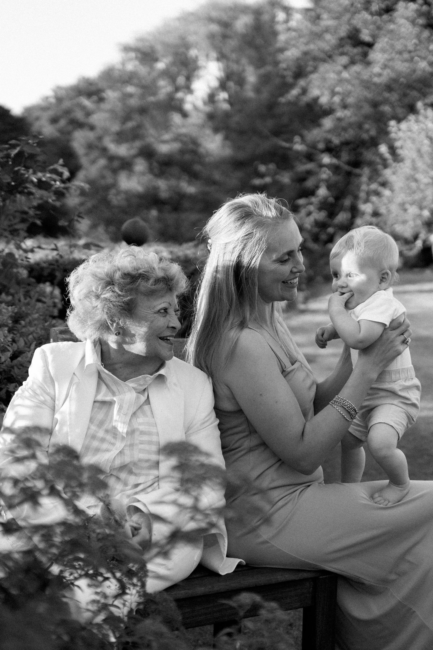 Black and white portrait series capturing intimate family moments outdoors.