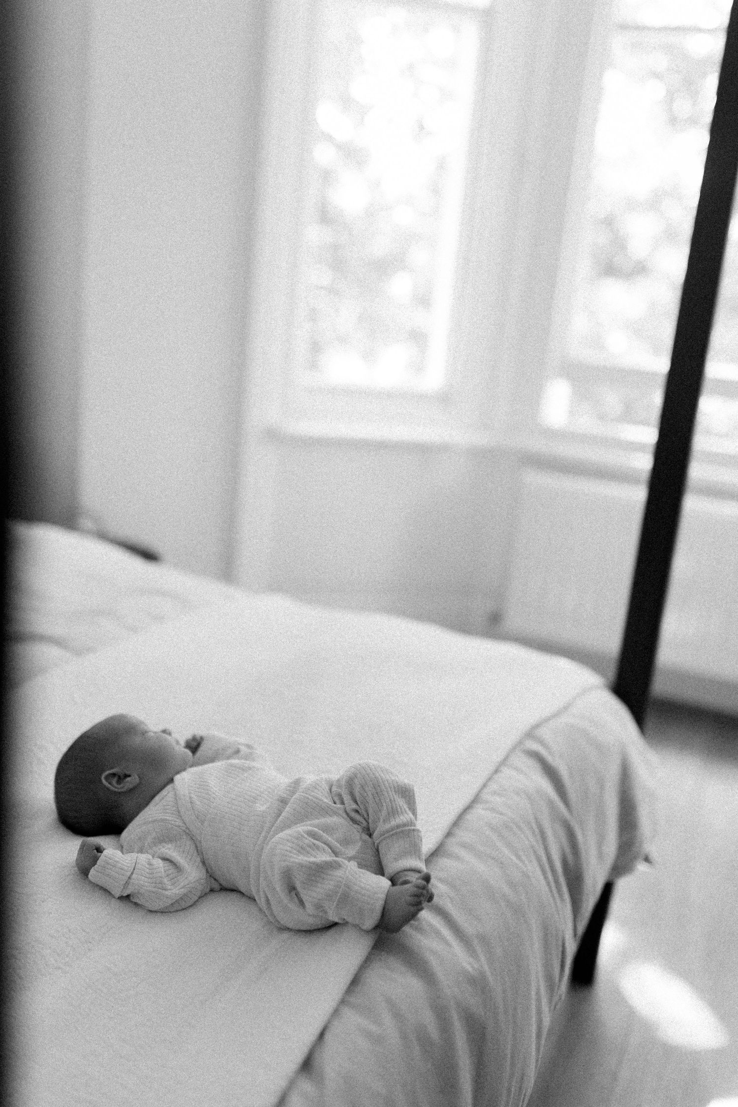 Black and white photo sequence showing a sleeping newborn baby in white bedding.
