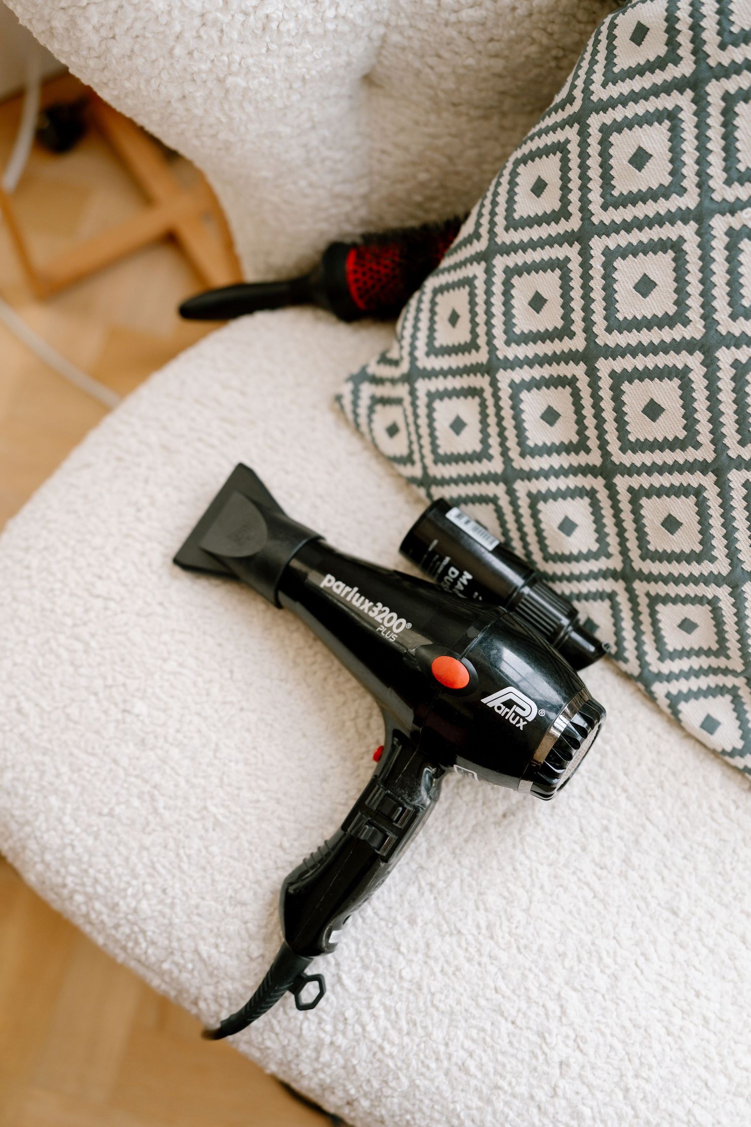 Hair styling tools and curling irons laid out on white towels.