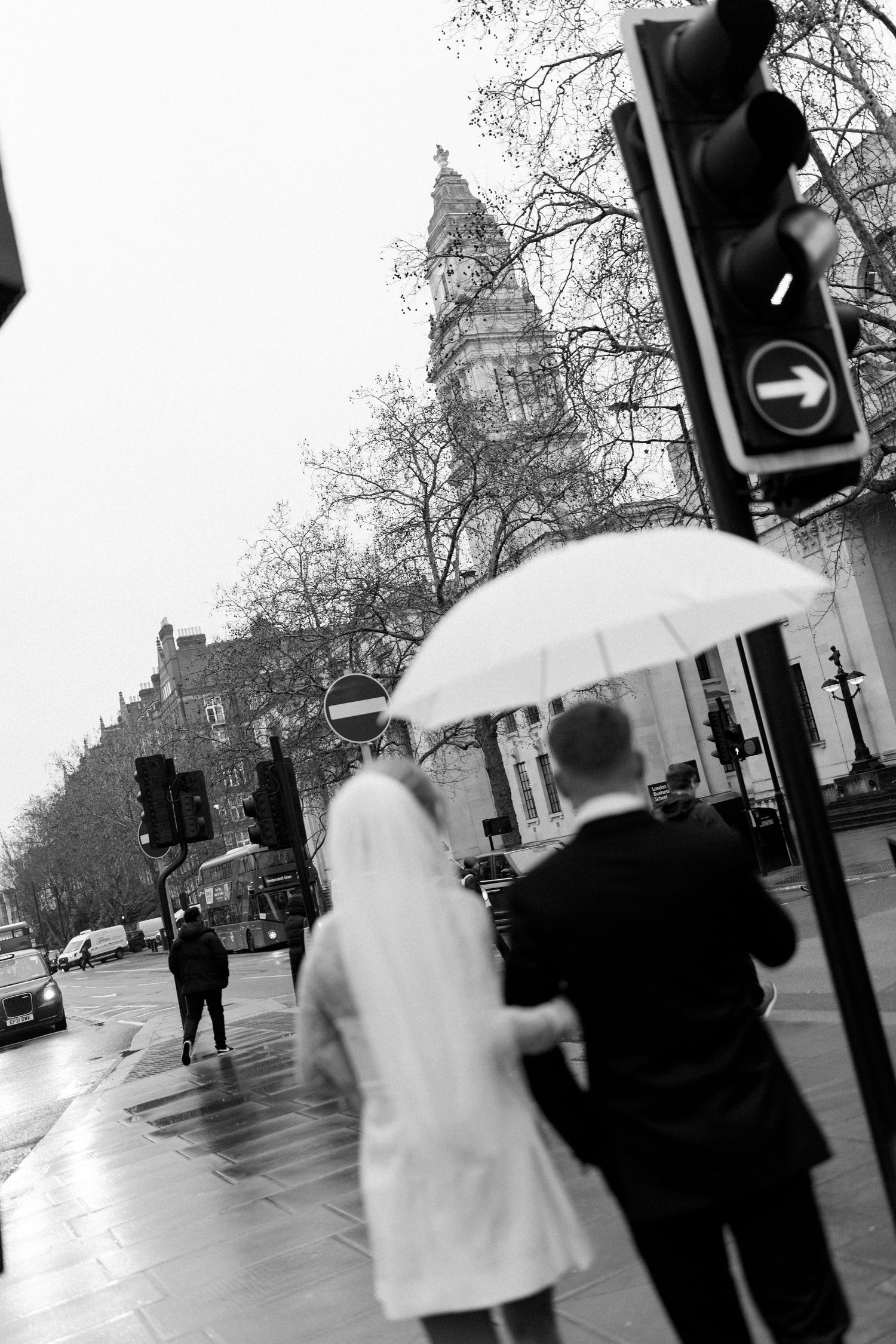 Black and white street scene with umbrellas on a rainy day in London.