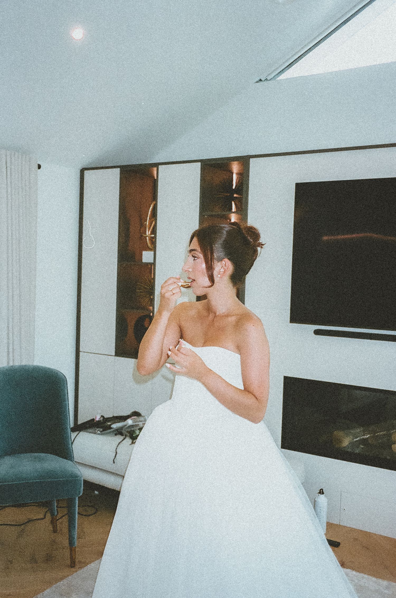 A bride in a white ballgown wedding dress drinks from a bottle while sitting on a blue chair in a sequence of photos.