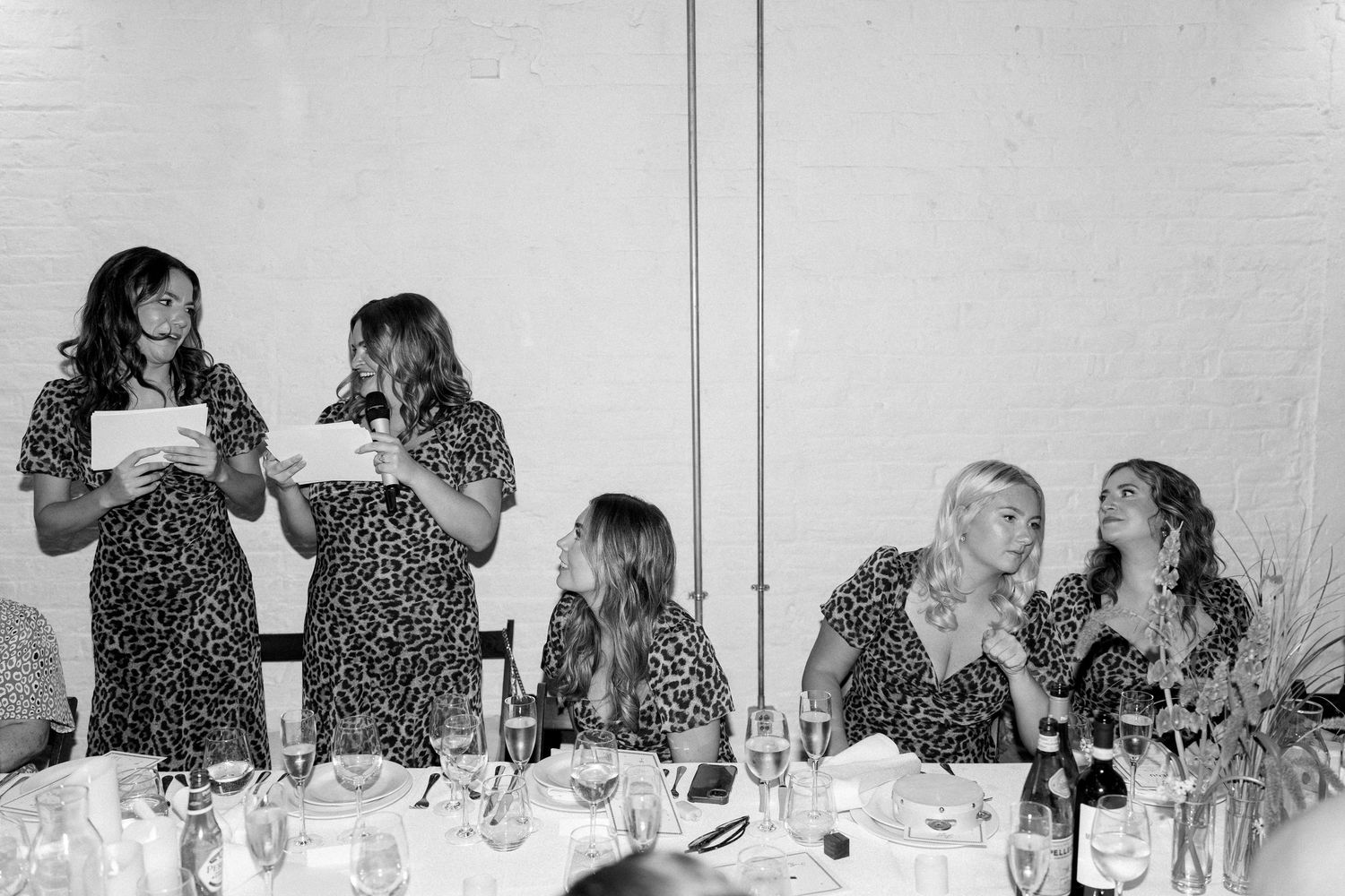 Wedding guests enjoy dinner and conversation at a reception table.