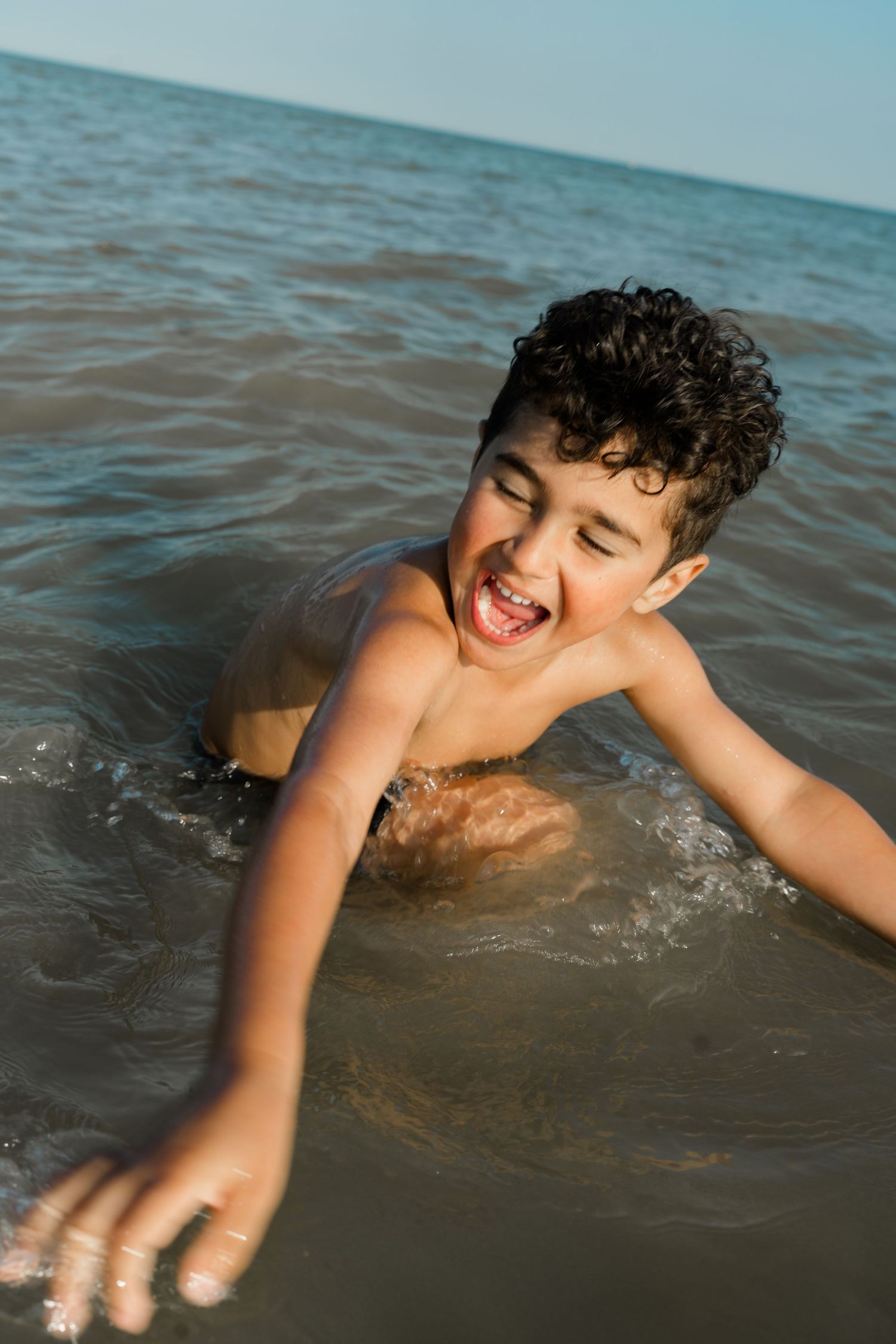 Playful swimming and splashing in the ocean during a summer day.