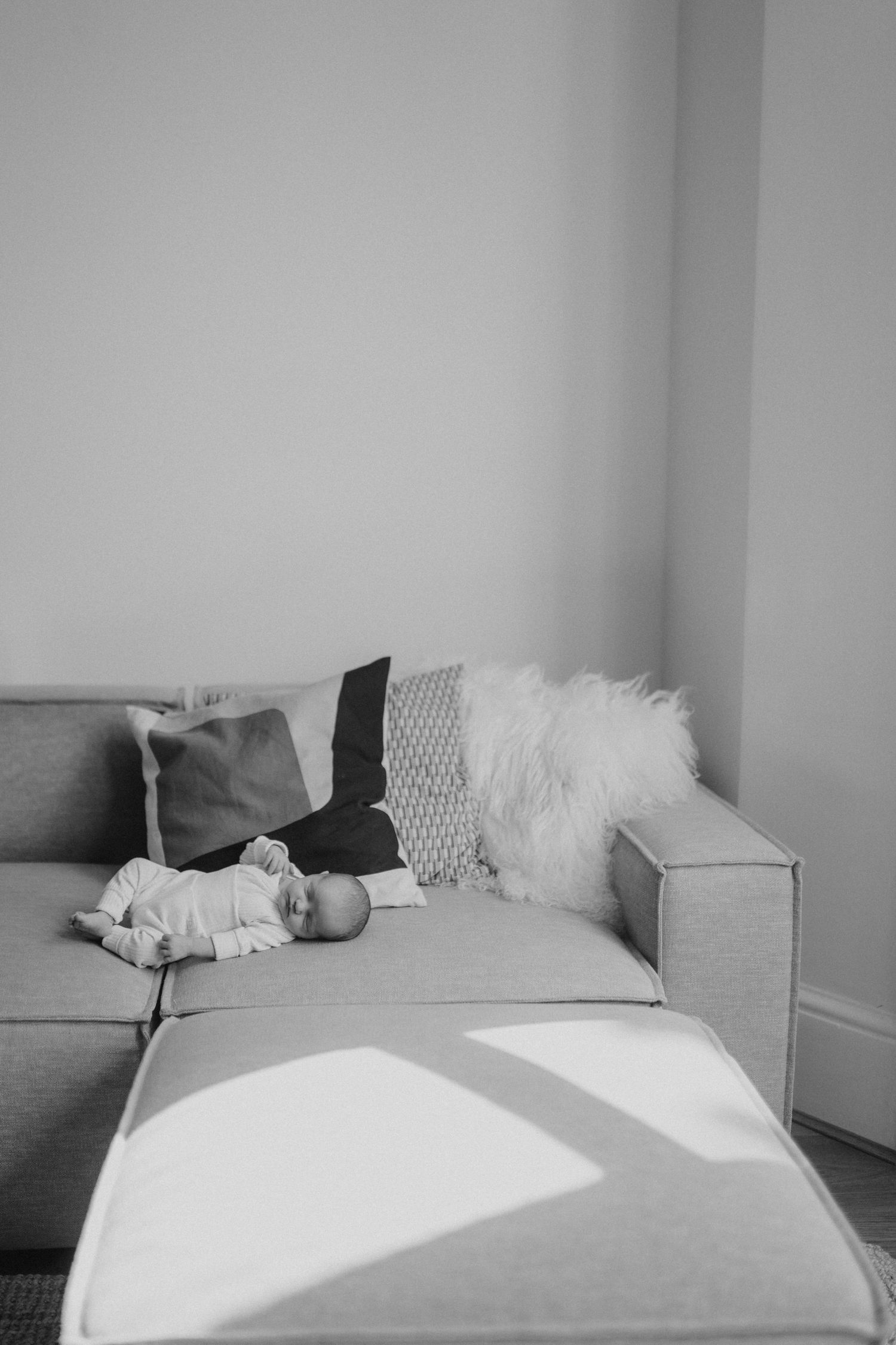 A minimalist bedroom with white bedding and soft natural lighting.