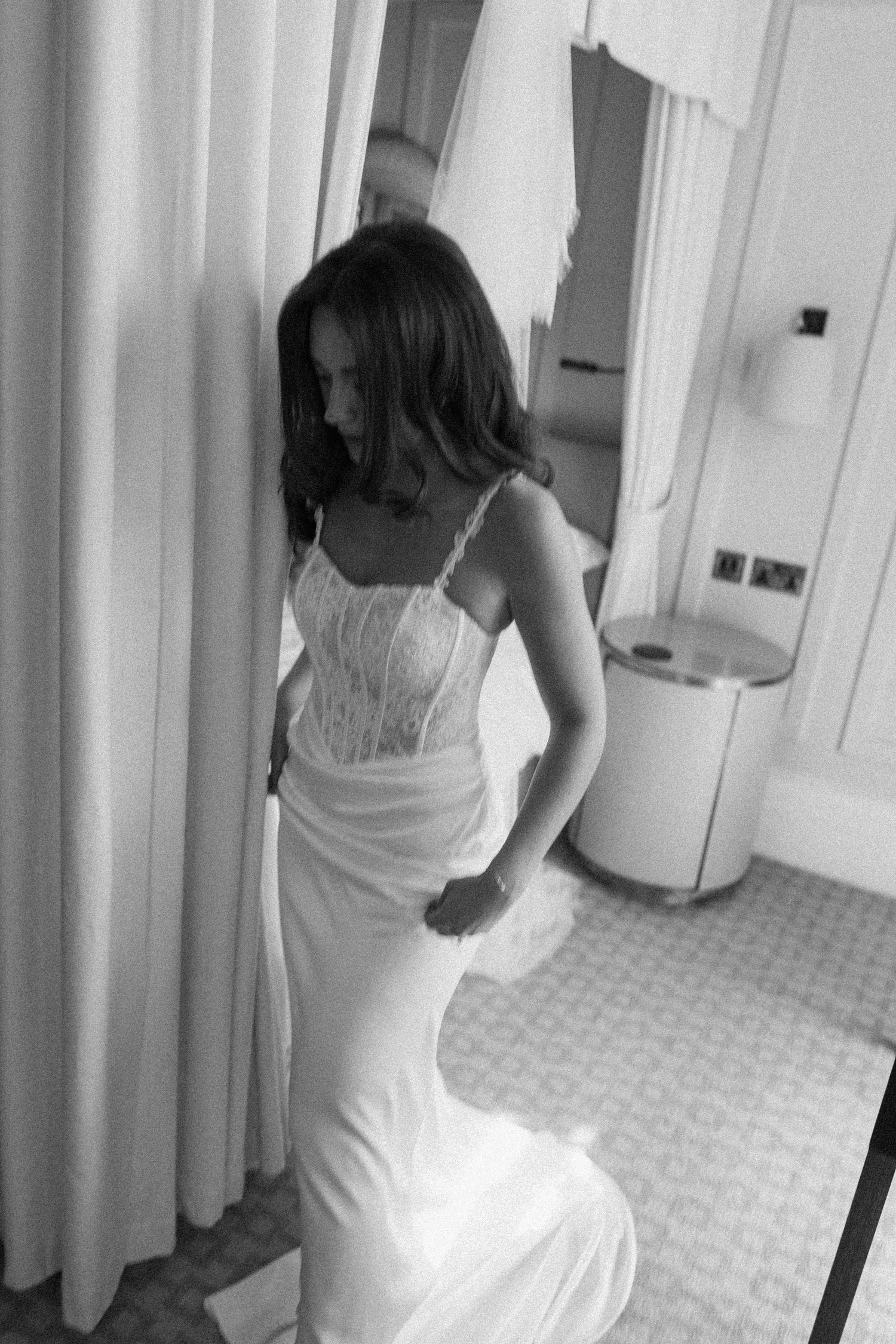 Elegant bride in a fitted lace corset wedding gown posing in black and white photo.