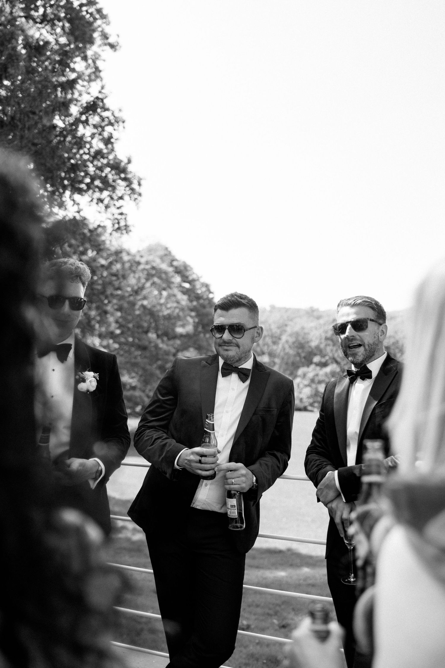 Men in tuxedos gathered outdoors at a formal event.