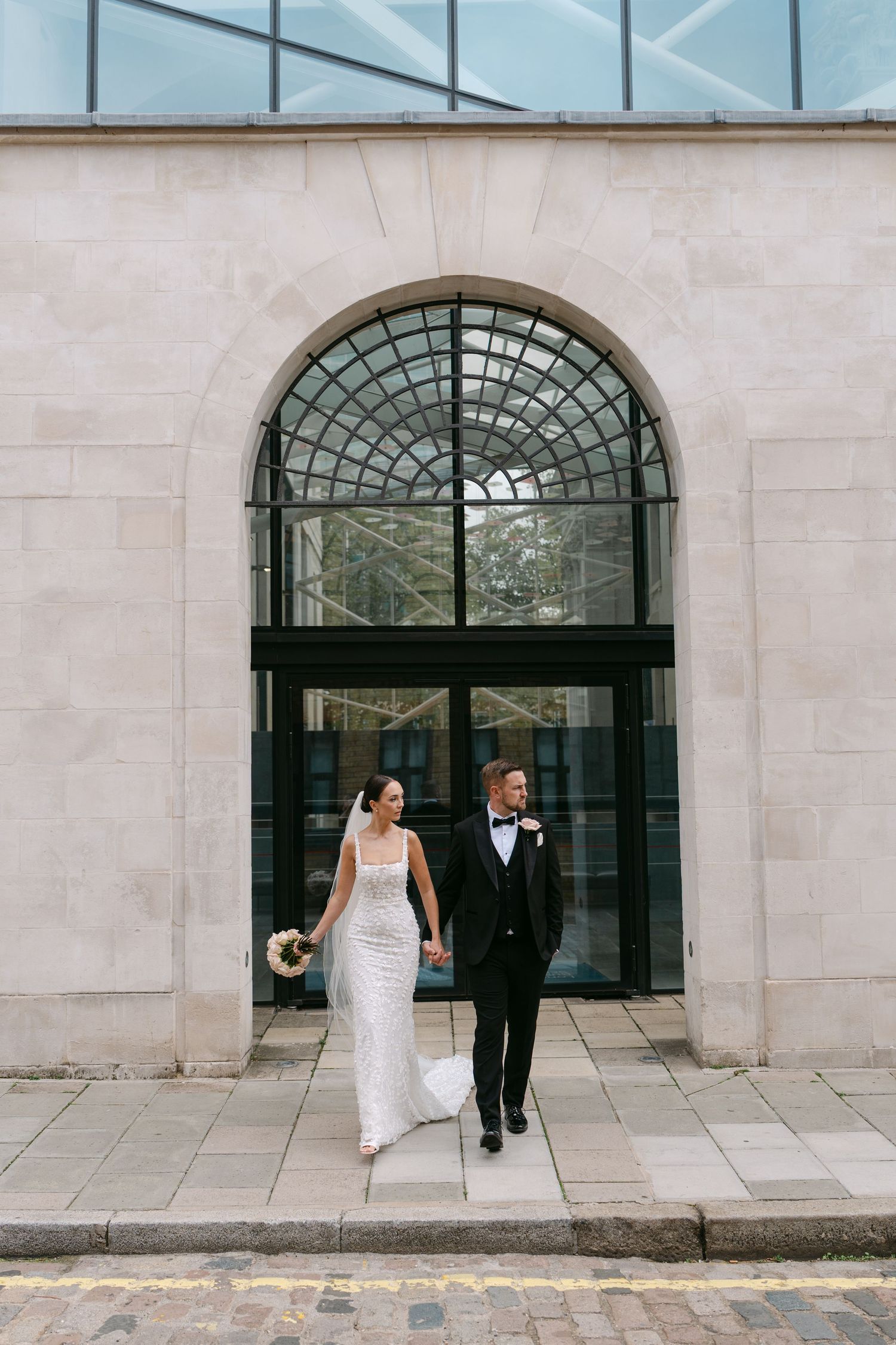 Wedding couple poses against elegant stone archways in a series of romantic shots.