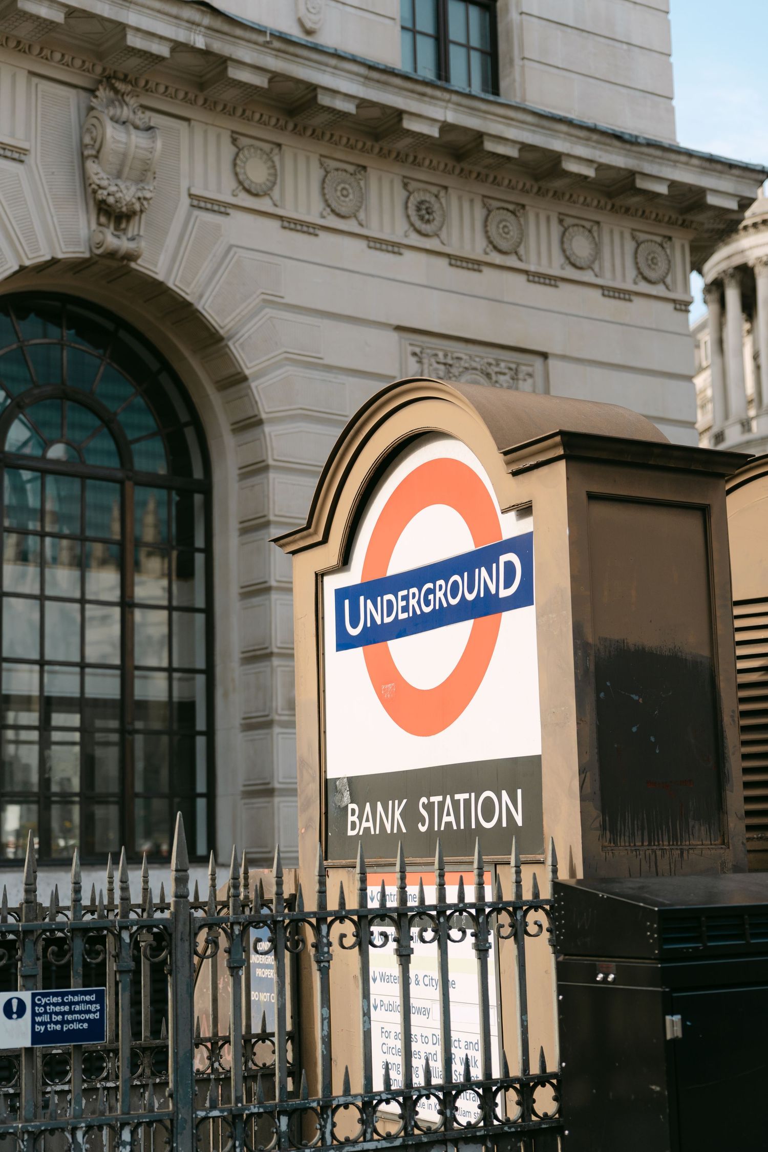 The iconic London Underground Bank Station entrance with its distinctive red roundel sign.