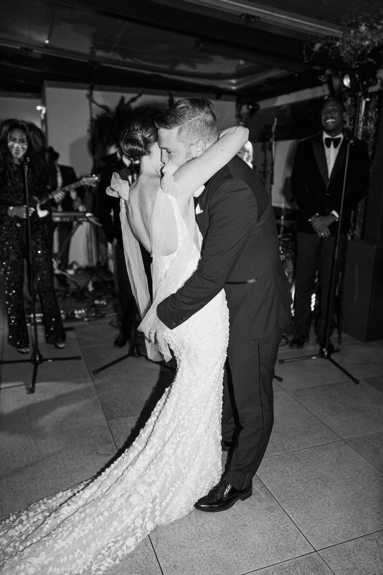 Romantic black and white photo of a couple embracing during their first dance.
