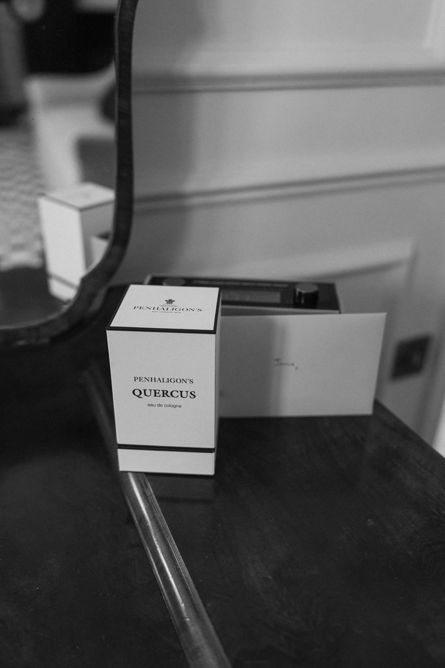 Black and white photo of Penhaligons Quercus eau de cologne perfume box on a dark wooden dresser.