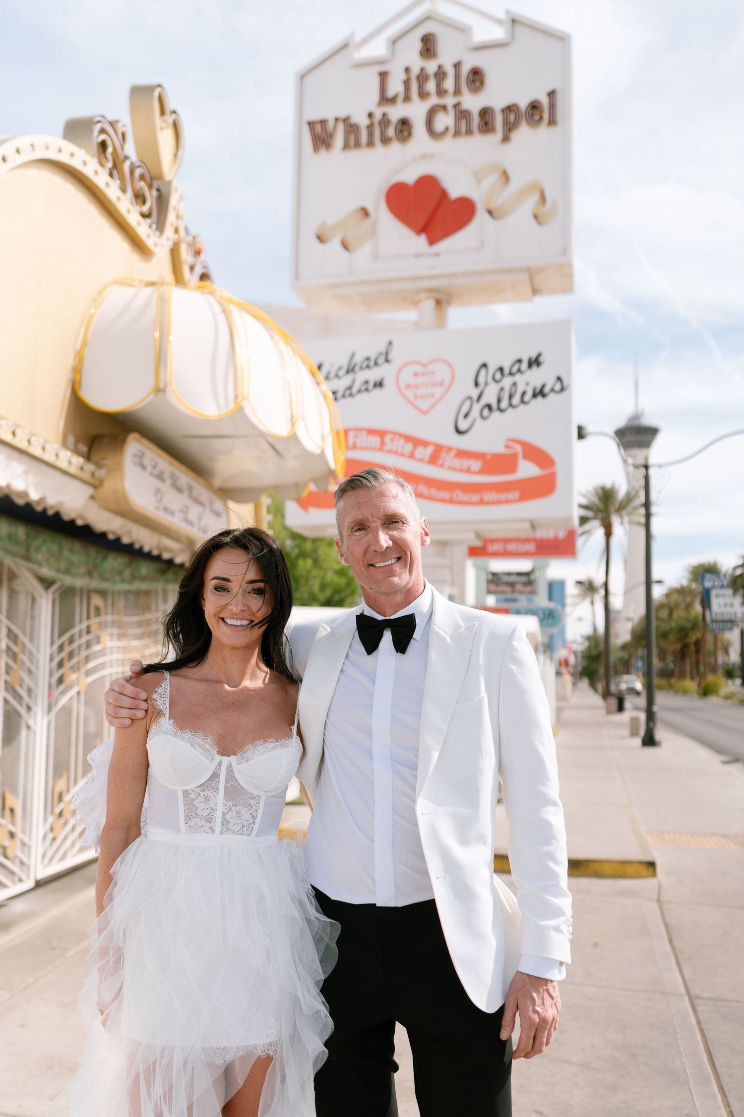 Newlyweds share joyful moments outside iconic Las Vegas wedding chapel.