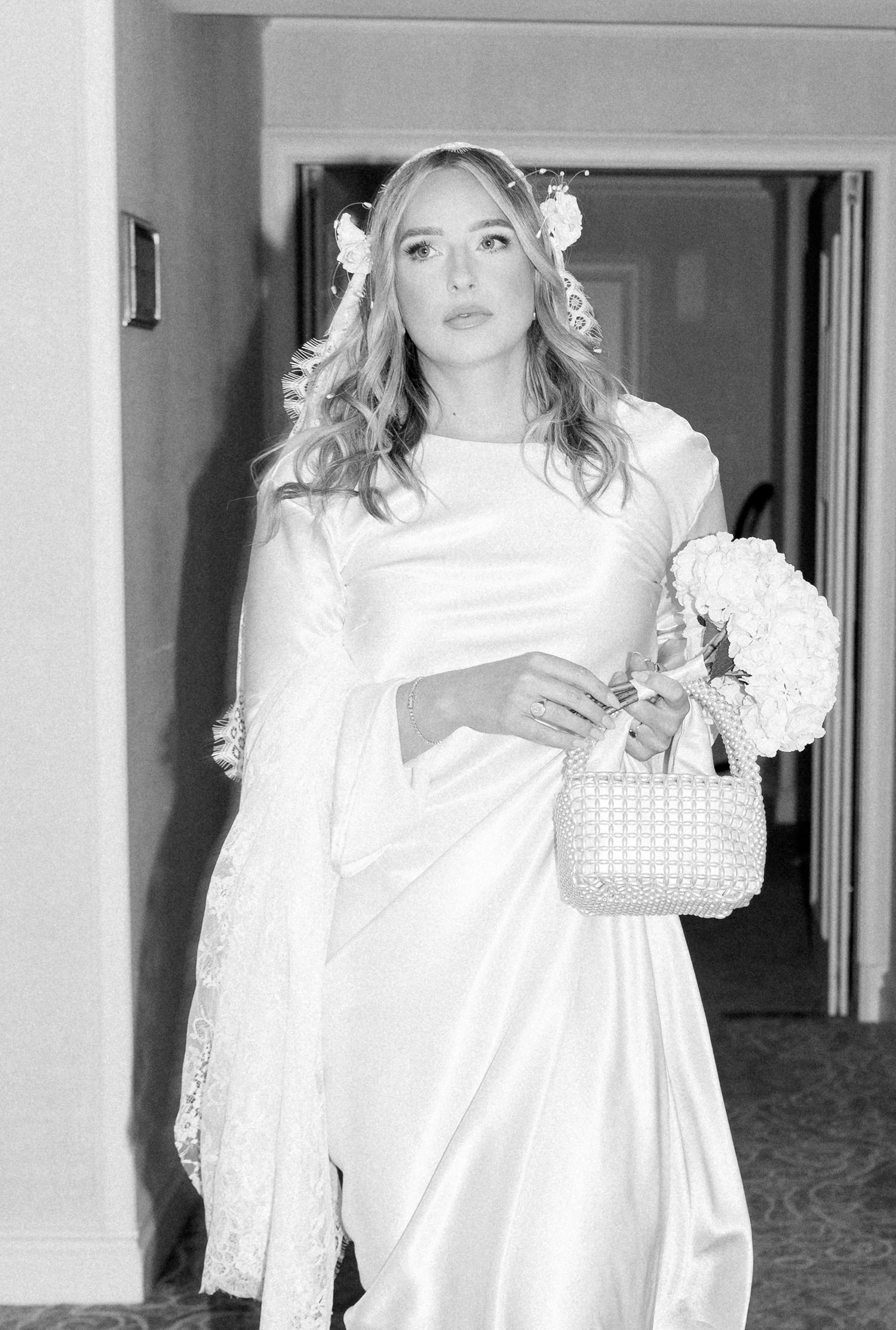 Black and white photo series showing a person in a white dress and veil walking through a hotel hallway.