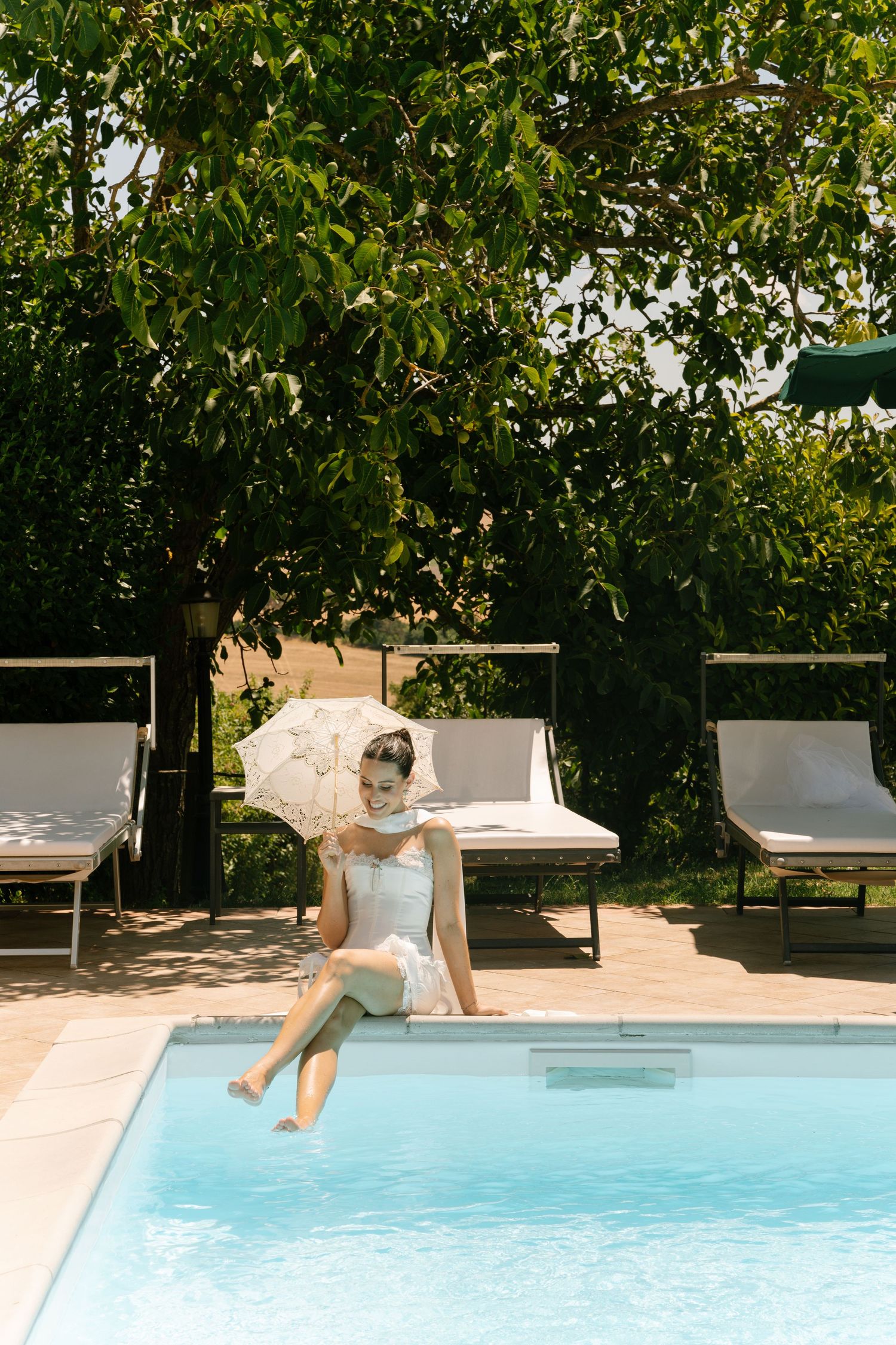 A series of photos showing someone playfully jumping into a swimming pool on a sunny day.