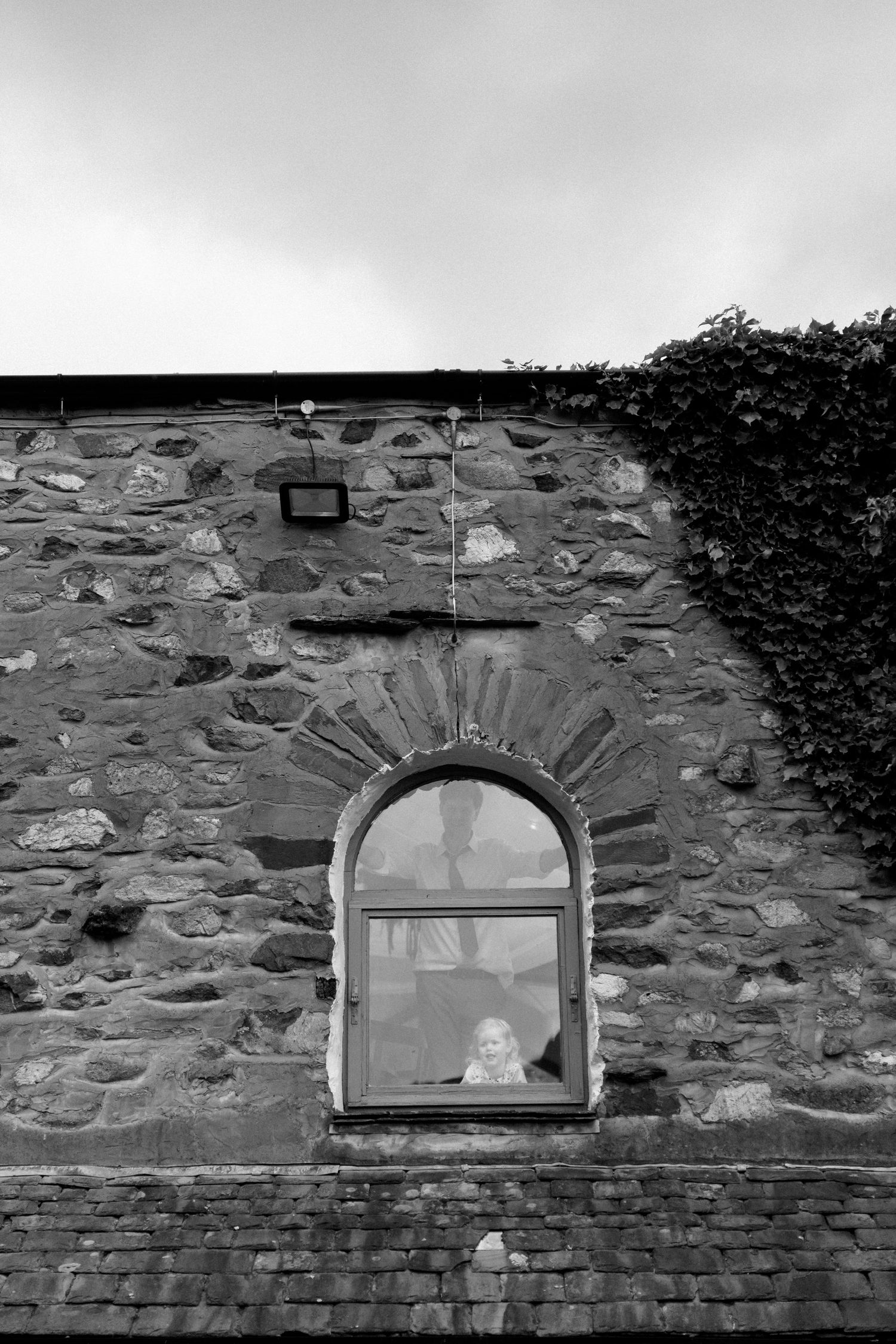 Stone wall with arched windows at a rustic wedding venue.