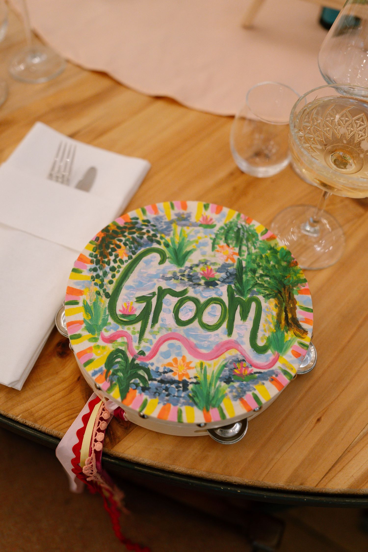 Colorful decorative welcome plates with tropical designs displayed on a wooden table.