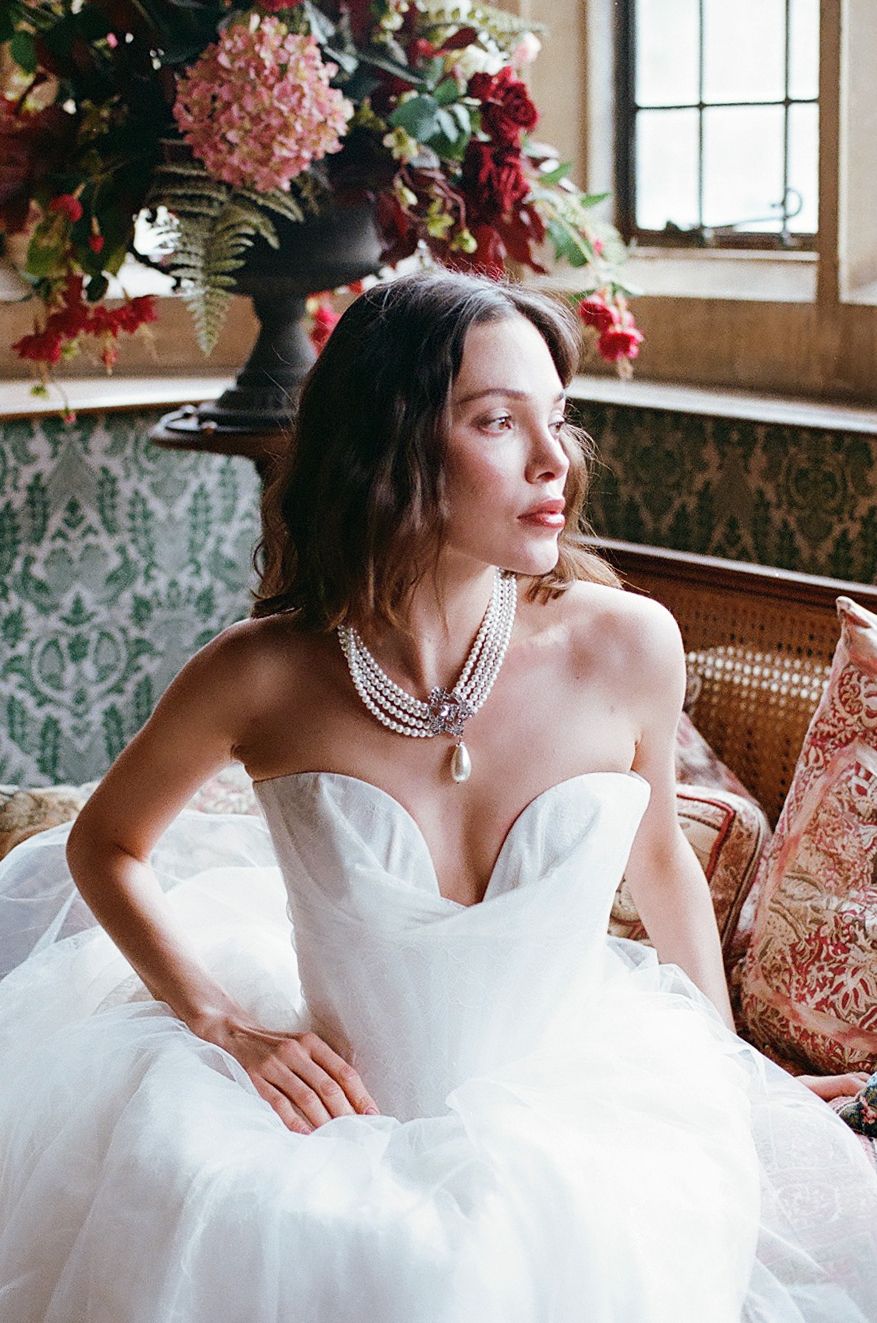 A dreamy bridal portrait series in a rustic venue with soft pink floral decor and natural window lighting.