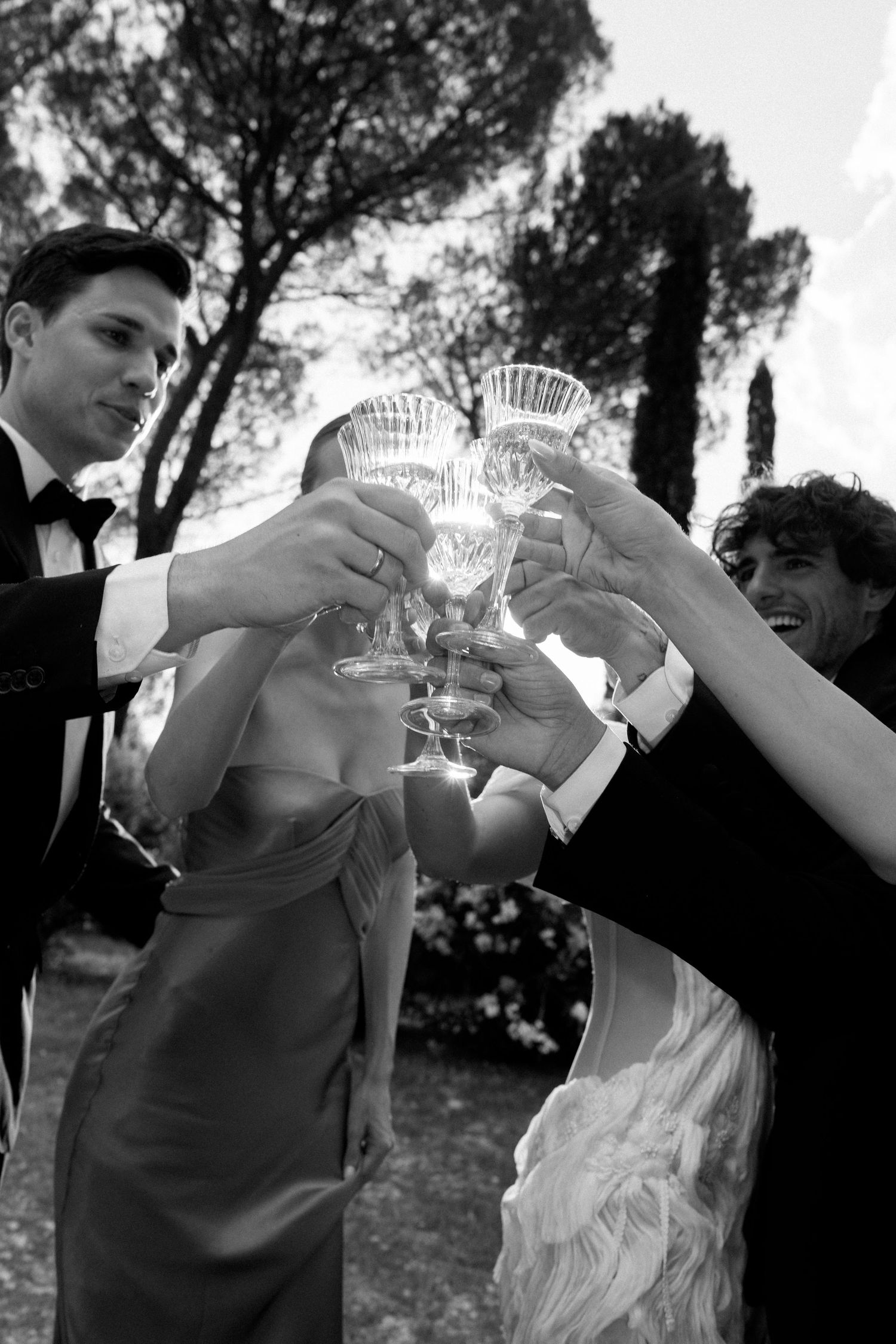 A sequence of black and white photos showing people toasting and clinking glasses together during a celebration.