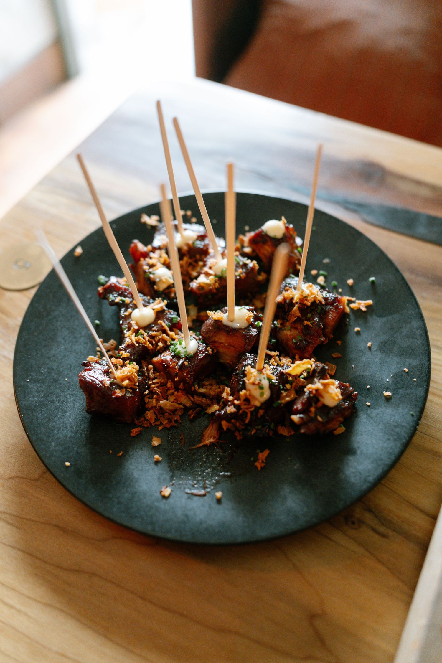 Gourmet appetizers with toothpicks displayed on dark slate plates.