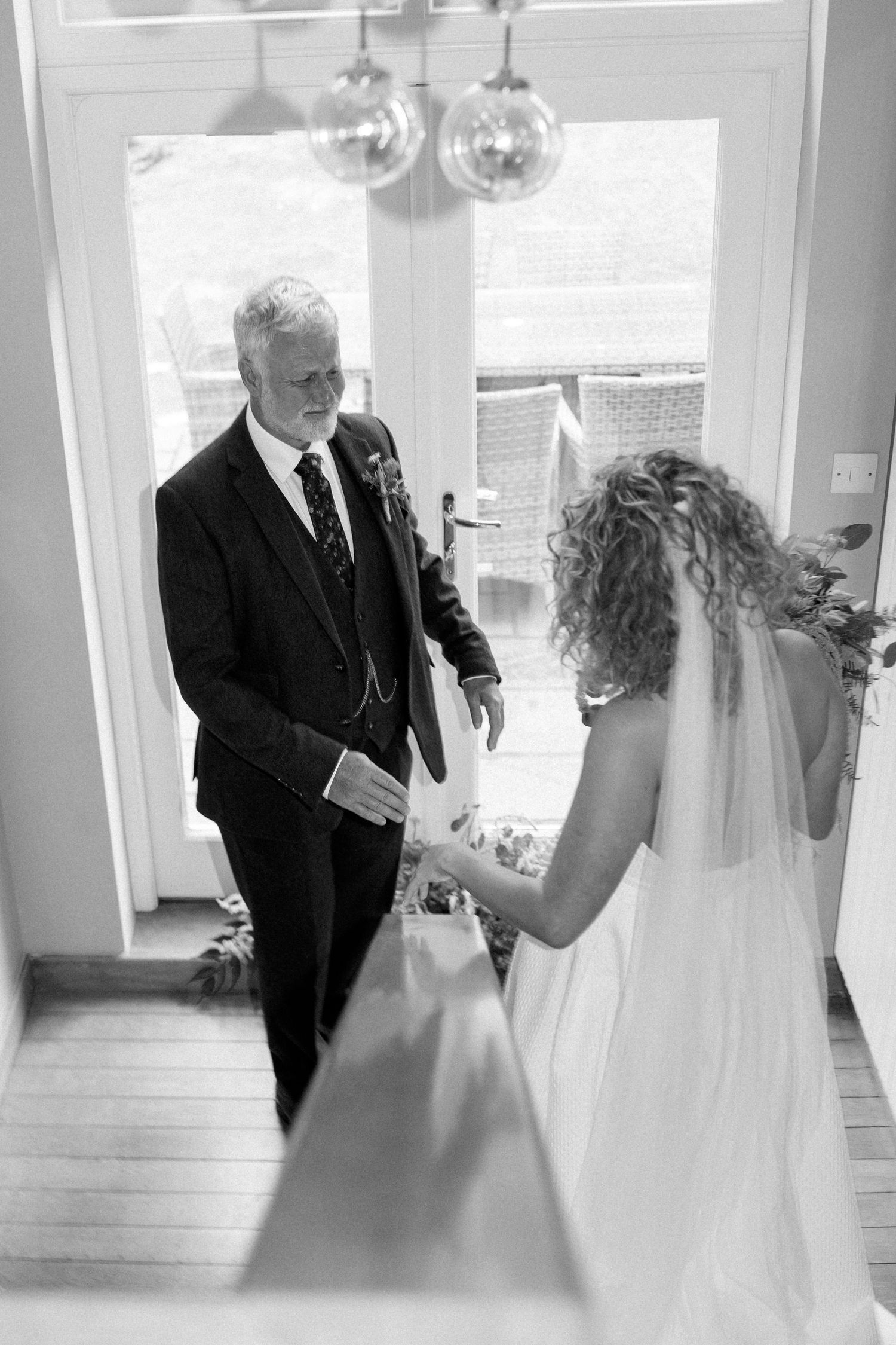 Black and white emotional first look moment between bride and father before wedding ceremony.