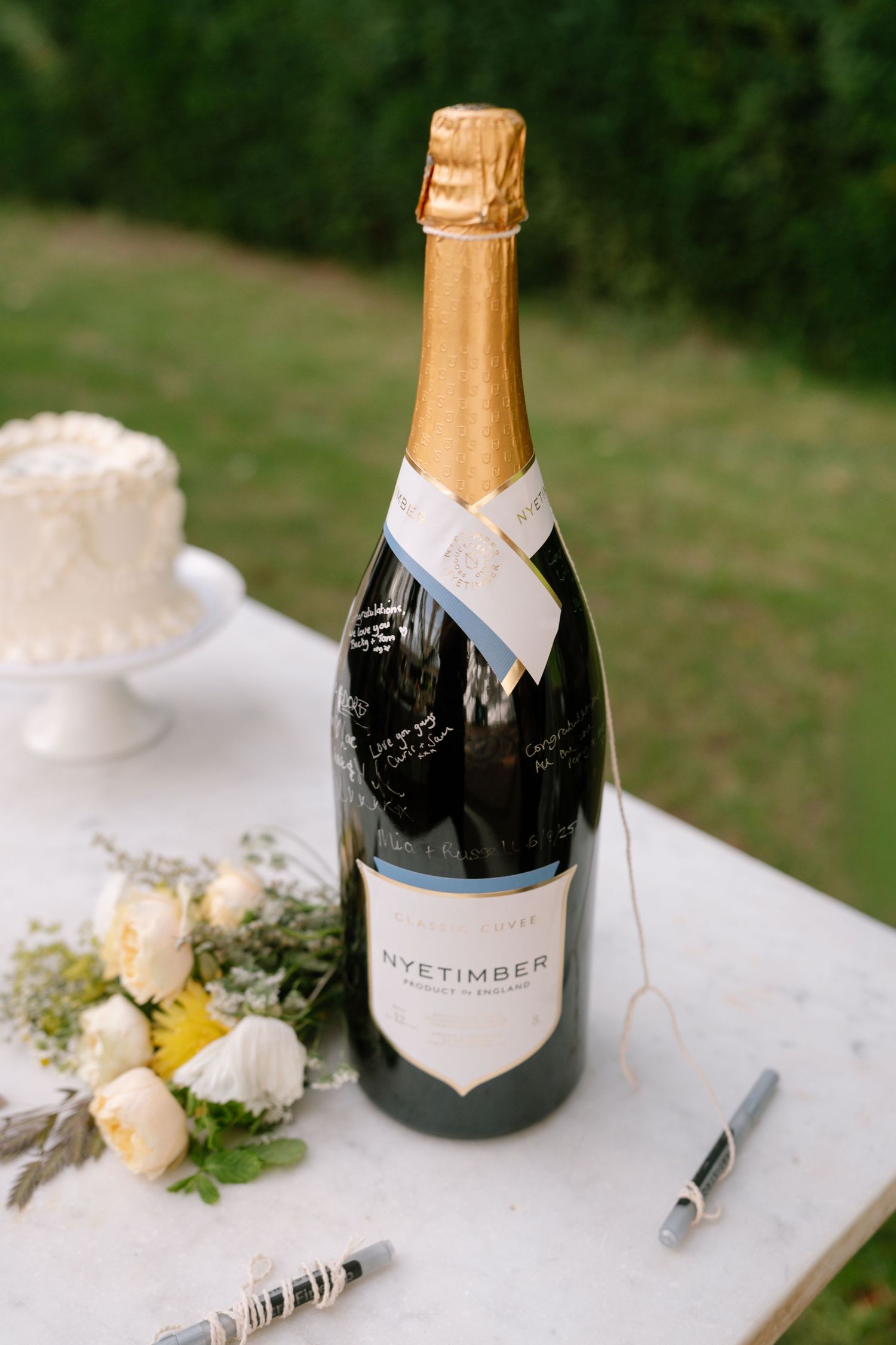 Elegant champagne bottles and floral decorations displayed on a white tablecloth.