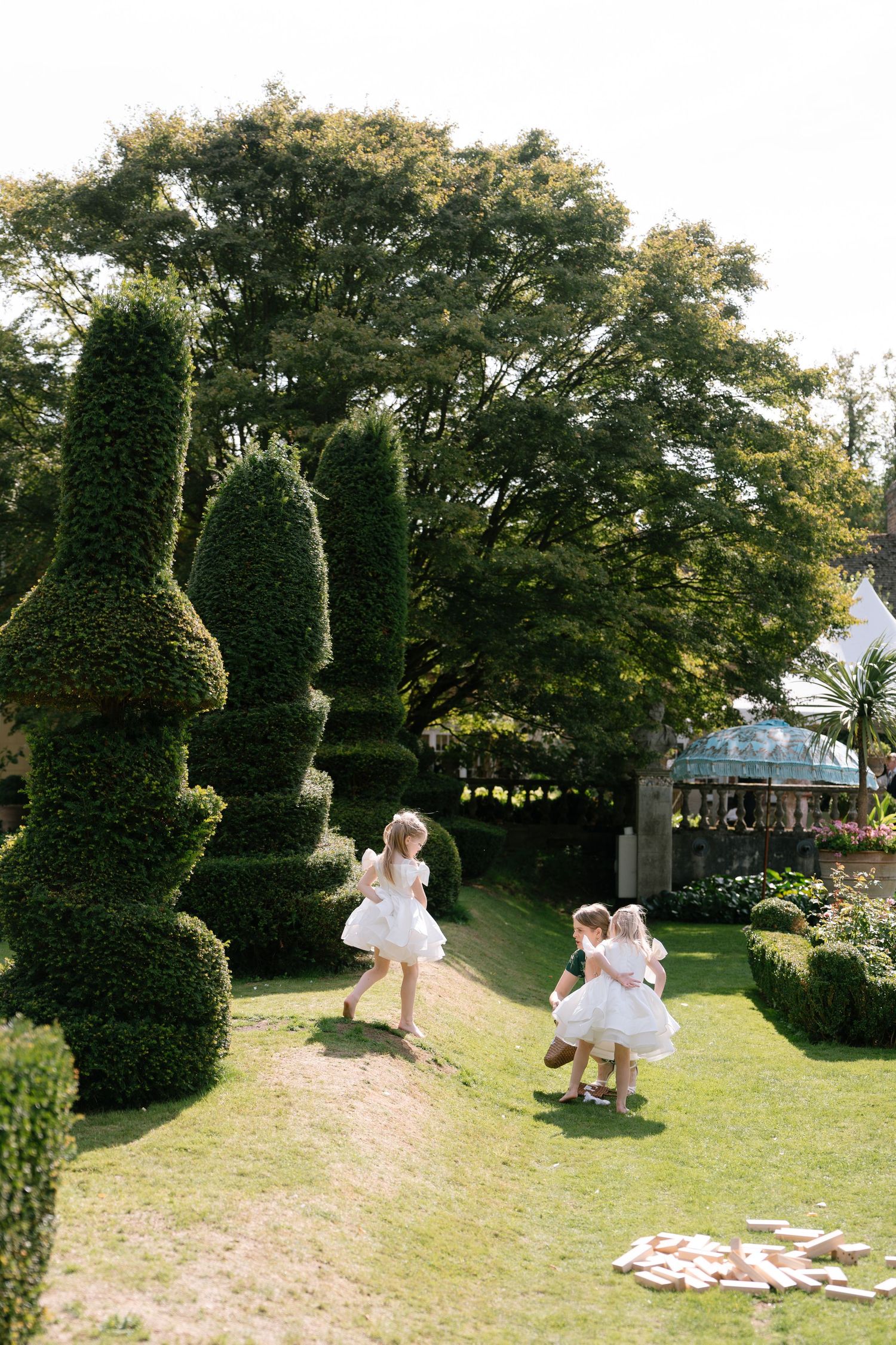 Children playing on grassy lawn during outdoor wedding reception.