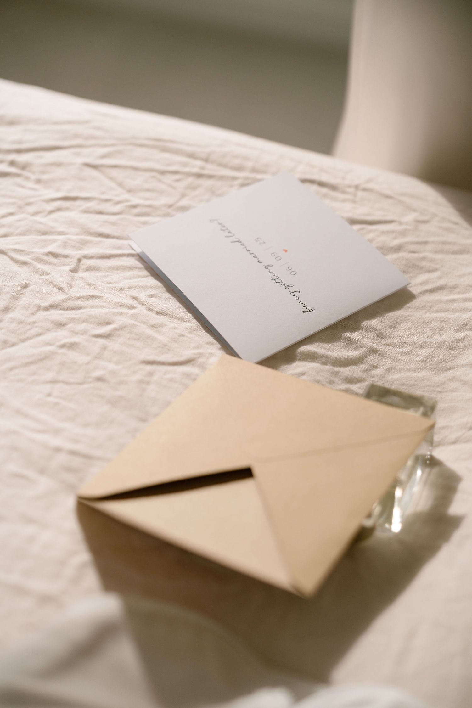 White envelopes and stationery arranged on a textured white surface.
