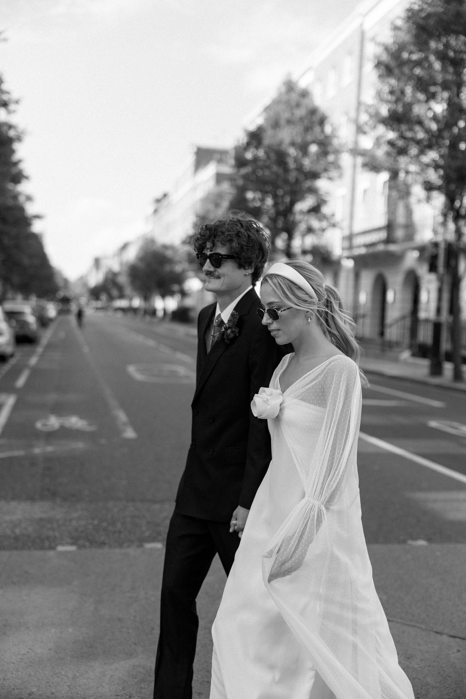 Black and white wedding portrait showing a couple embracing on a city street.